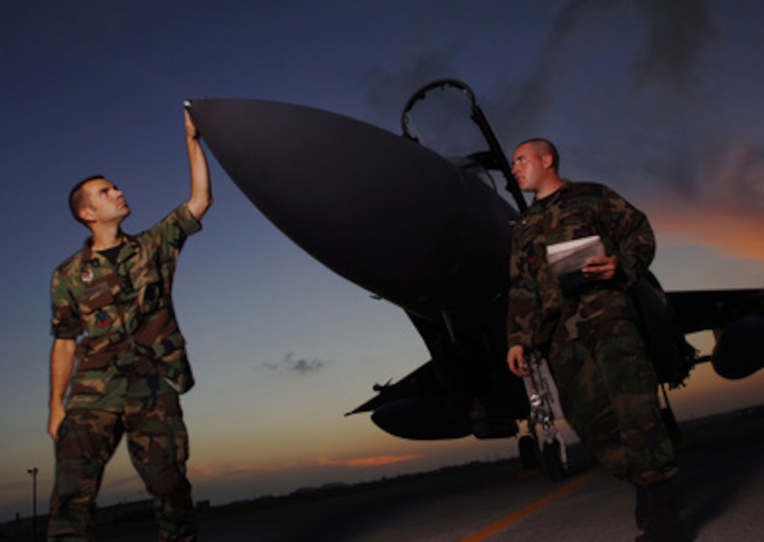 F-15 Eagle Crew Chiefs Staff Sgts. Andrew Johnson (left) and Brian Goodman inspect their aircraft on the flight line at Kadena Air Base, Japan, on Aug. 17, 2005. Johnson and Goodman are deployed to Kadena from the 391st Fighter Squadron, Mountain Home Air Force Base, Idaho, along with approximately 300 other Idaho airmen to support Pacific Command operations. 