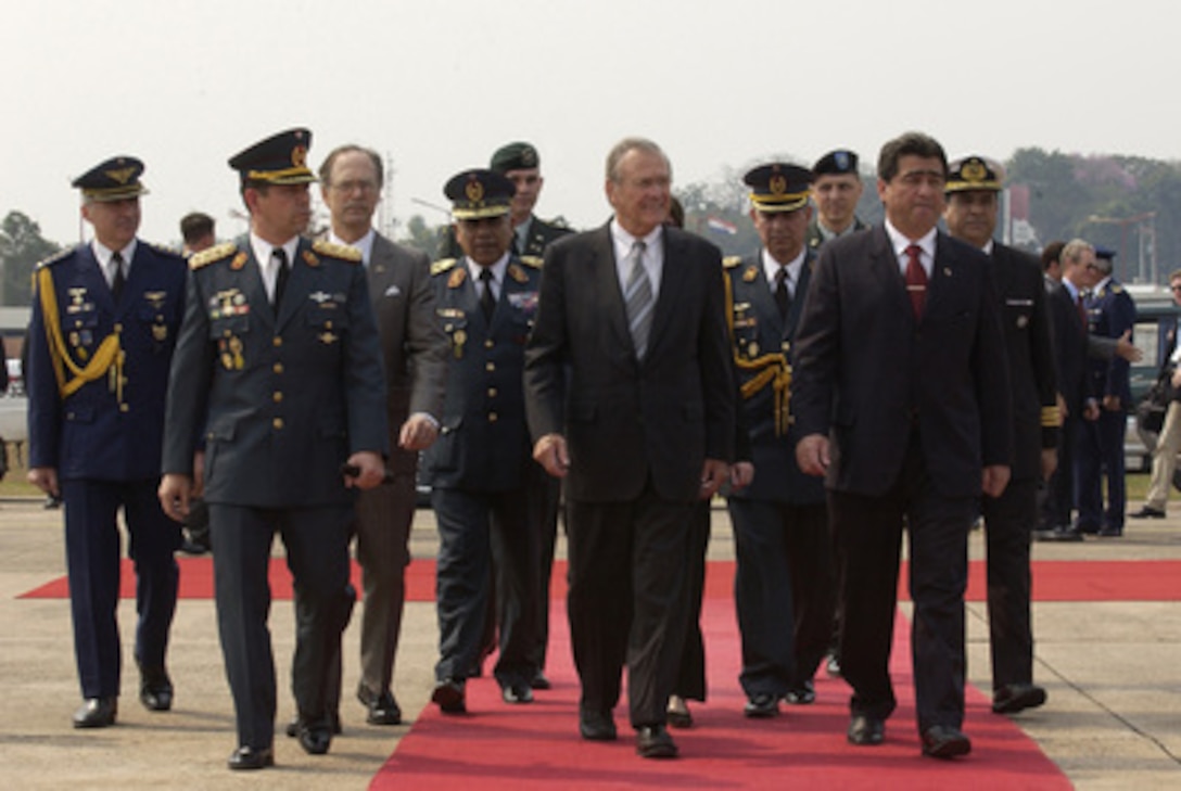 Senior members of the Paraguayan military and Paraguay's Minister of National Defense Roberto Gonzalez (right) escort Secretary of Defense Donald H. Rumsfeld (center) to his aircraft at Silvio Pettirossi International Airport in Asuncion, Paraguay, on Aug. 17, 2005. Rumsfeld visited Paraguay to meet with his counterpart Gonzalez and Paraguayan President Nicanor Duarte-Frutos to discuss bilateral military cooperation in the region. 