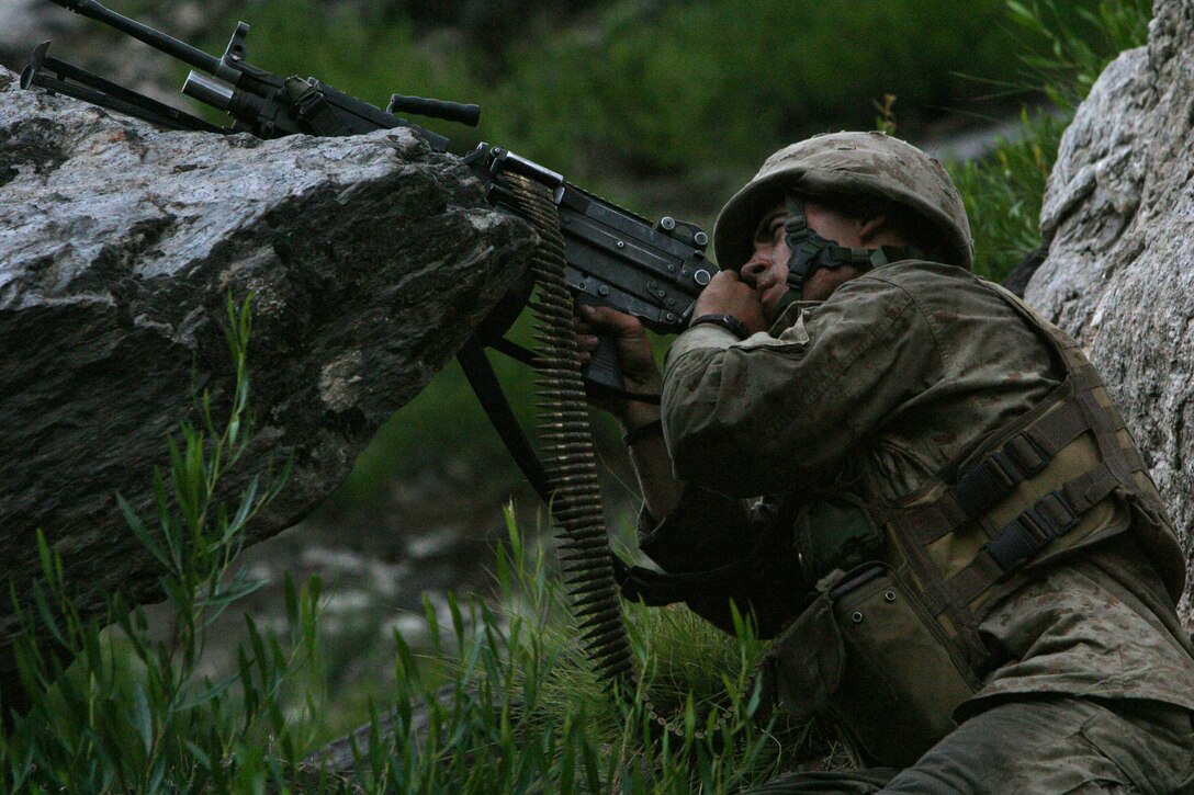 Lance Cpl. Ryan R. Irving, infantryman with 2nd Battalion, 3rd Marine Regiment, returns fire at insurgents in the Korengal Valley. The Elburn, Ill., native was one of the Marines with E Company that repelled an insurgent ambush Aug. 18.