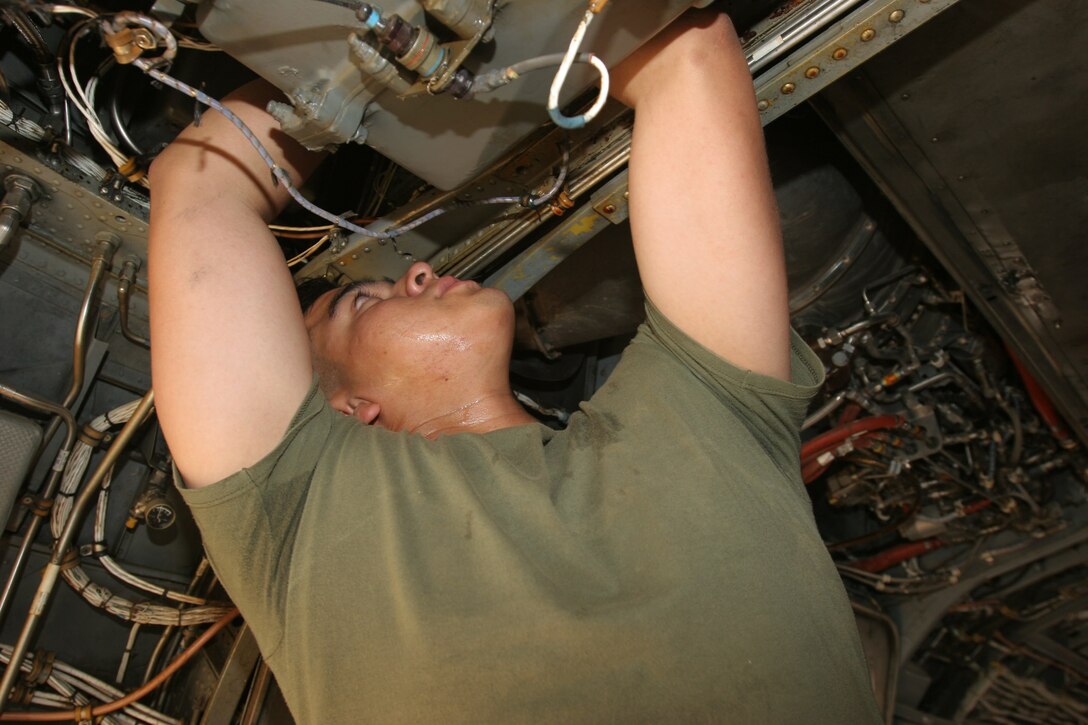 AL ASAD, Iraq ? Corporal Marcos Cortez, an avionics technician with Marine Medium Helicopter Squadron 266 and Chicago, native, makes repairs in the rear of the aircraft on board a CH-46 on Aug. 19. Cortez and his fellow maintenance Marines are adjusting to operating in a combat environment along with Iraq?s harsh conditions.