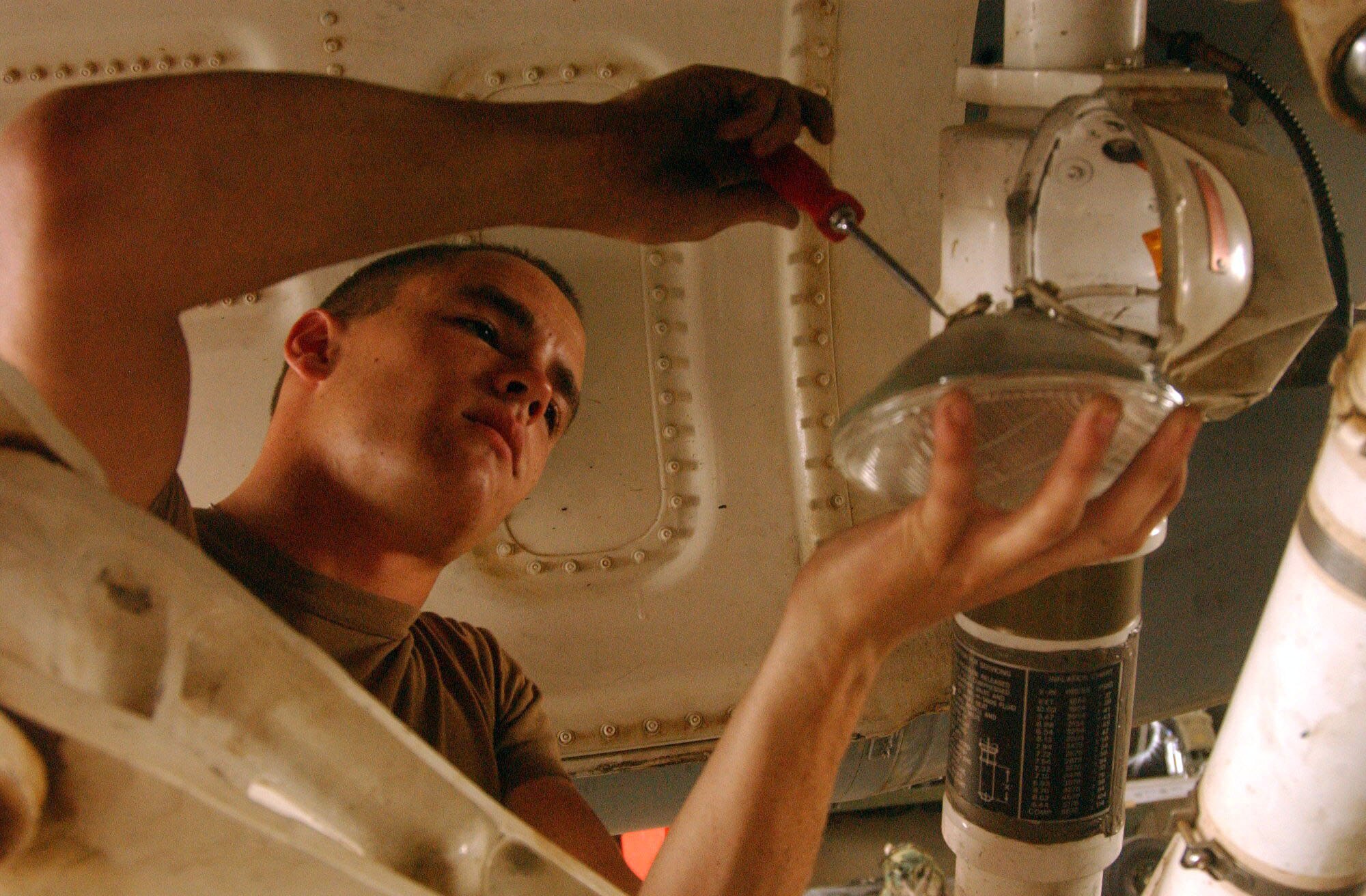BALAD AIR BASE, Iraq -- Senior Airman Jacob Wheeler replaces a burned-out taxi light on an F-16 Fighting Falcon.  The 332nd Expeditionary Fighter Squadron includes Air National Guardsmen from Texas, Minnesota and Arkansas as well as active-duty Airmen of the 510th EFS from Aviano Air Base, Italy.  Airman Wheeler is a 332nd EFS crew chief who is deployed from the Texas ANG's 147th Fighter Wing.  (U.S. Air Force photo by Senior Airman Shaun Emery)