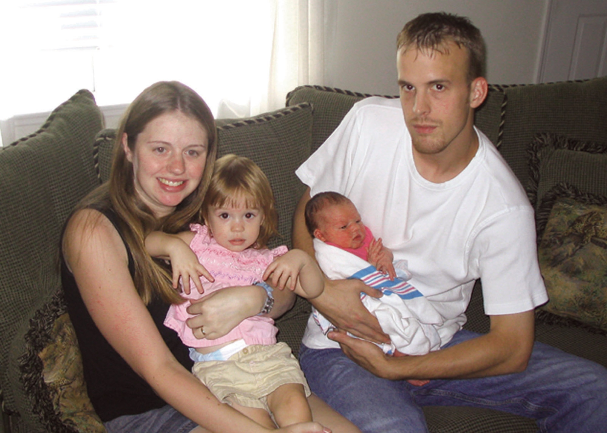 MOODY AIR FORCE BASE, Ga. -- Staff Sgt. David Hayes holds his newborn daughter, Caysie, while his wife, Charlotte, holds their 20-month-old daughter, Madison.  Sergeant Hayes delivered Caysie in the bathroom of their home when they were unable to get to the hospital in time. He is assigned to the 347th Aircraft Maintenance Squadron. (U.S. Air Force photo by 1st Lt. Dustin Hart)