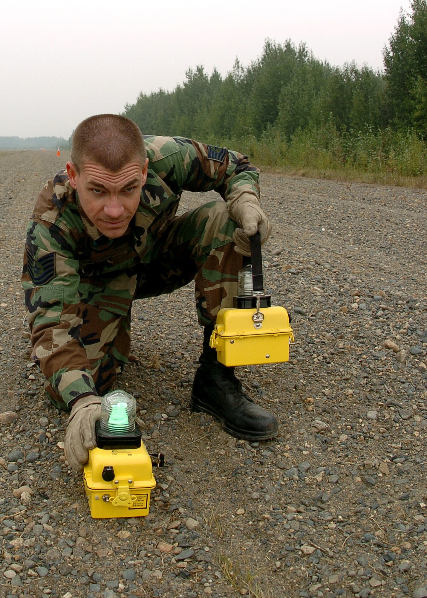 RED DEVIL, Alaska -- Tech. Sgt. Greg Eckroth aligns a light during installation of a portable runway lighting system Aug. 17. The deployment of the system was part of the Alaska Shield/Northern Edge 05 exercise. The runway lights will allow air transportation to and from the remote landlocked village during nighttime. Sergeant Eckroth is assigned to the 611th Civil Engineer Squadron at Elmendorf Air Force Base, Alaska. (U.S. Navy photo by Petty Officer 2nd Class Michael Hight)