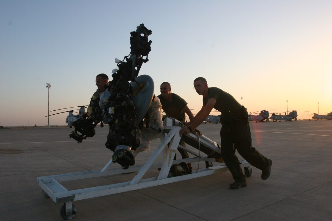 AL ASAD, Iraq ? A group of Marine Medium Helicopter Squadron 161 maintenance Marines roll a CH-46 rotor down the flightline here before putting the final Greyhawk helicopters together. The squadron had to install the engines and rotors here and will fly them to a forward operating base this week.
