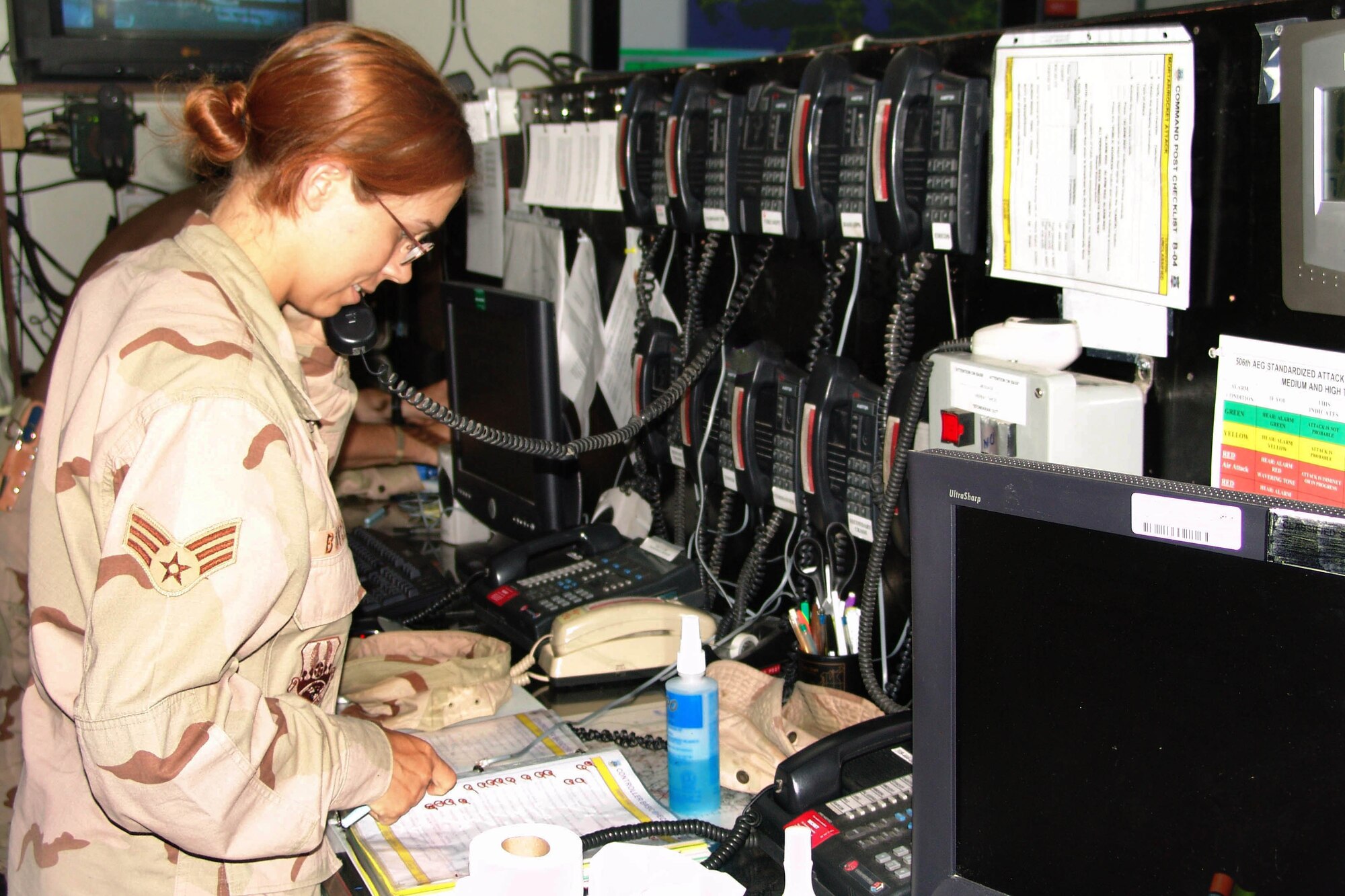 KIRKUK AIR BASE, Iraq -- Senior Airman Meghan Boyce runs a checklist in the command post here.  She is a command post controller with the 506th Air Expeditionary Group.  (U.S. Air Force photo by Tech. Sgt. J. LaVoie)