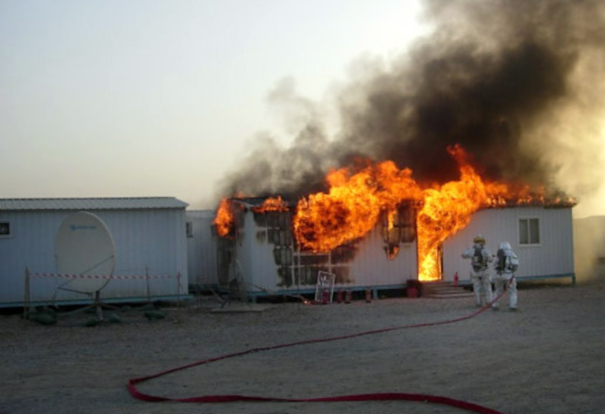 ALI BASE, Iraq -- Firefighters from the 407th Expeditionary Civil Engineer Squadron put out a fire Aug. 15 at a trailer behind the dining facility on the Army side of the installation just hours after they accepted fire protection responsibilities for the entire post. (U.S. Air Force photo)
