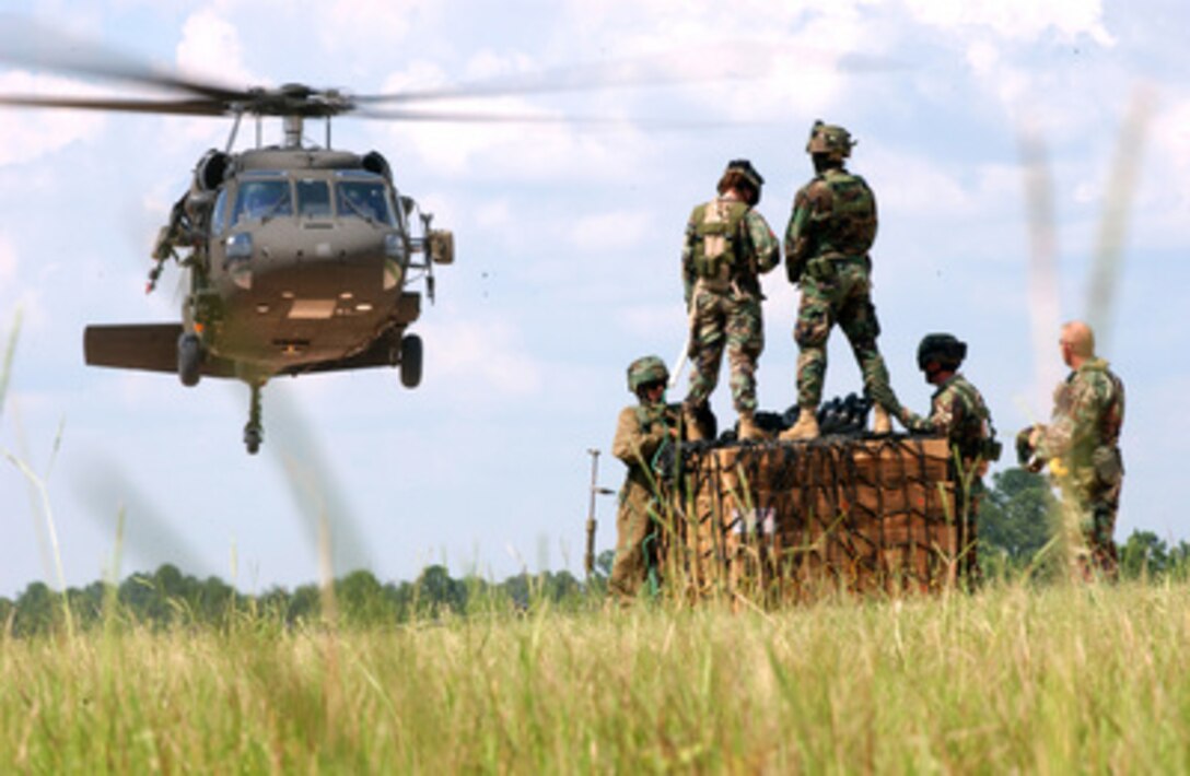 Soldiers of the 82nd and 101st Medical Companies of Fort Riley, Kan., watch as an MH-60 Black Hawk helicopter approaches to pick up a sling load of cargo during aeromedical evacuation training at the Joint Readiness Training Center, Fort Polk, La., on Aug. 18, 2005. 