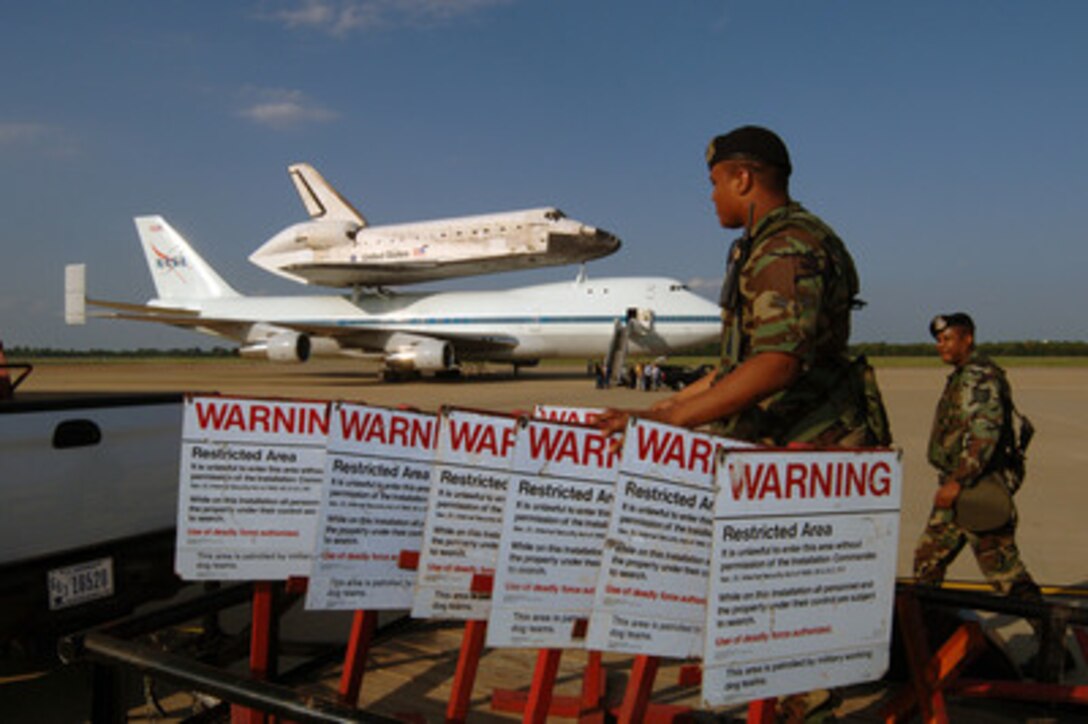 Air Force Security Forces personnel set up a security perimeter around the space shuttle Discovery and NASA's 747 Shuttle Carrier aircraft at Barksdale Air Force Base, La., on Aug. 19, 2005. The 747 and its piggy-backed Discovery stopped for a planned overnight refueling on its way back to Kennedy Space Center, Fla. 