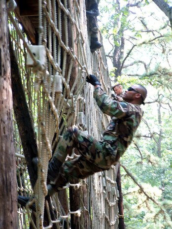 FORT DIX, N.J. -- Staff Sgt. Sy Pinthong climbs a cargo net on the obstacle course during contingency skills training here. Sergeant Pinthong, along with more than 50 other Airmen, completed the weeklong training course in preparation for deployment. He is a combat camera craftsman from Charleston Air Force Base, S.C. (U.S. Air Force photo by Tech. Sgt. Scott T. Sturkol) 