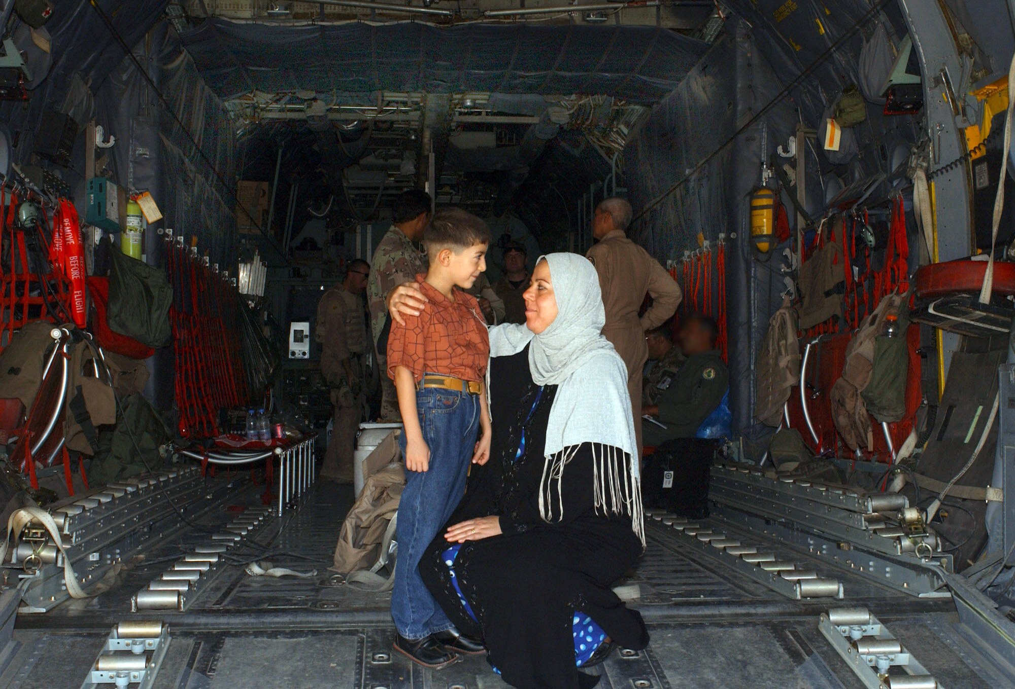 ALI BASE, Iraq -- Baher, 8, waits with his mom, Afaf, aboard an Iraqi C-130 Hercules flown by a joint Iraq-U.S. crew to begin the first leg of a journey to New Orleans where Baher will receive heart surgery. Ali Base is home to the 407th Air Expeditionary Group that trains more than 100 Iraqi airmen to maintain and fly the C-130. (U.S. Air Force photo by Tech. Sgt. Brian Davids)  