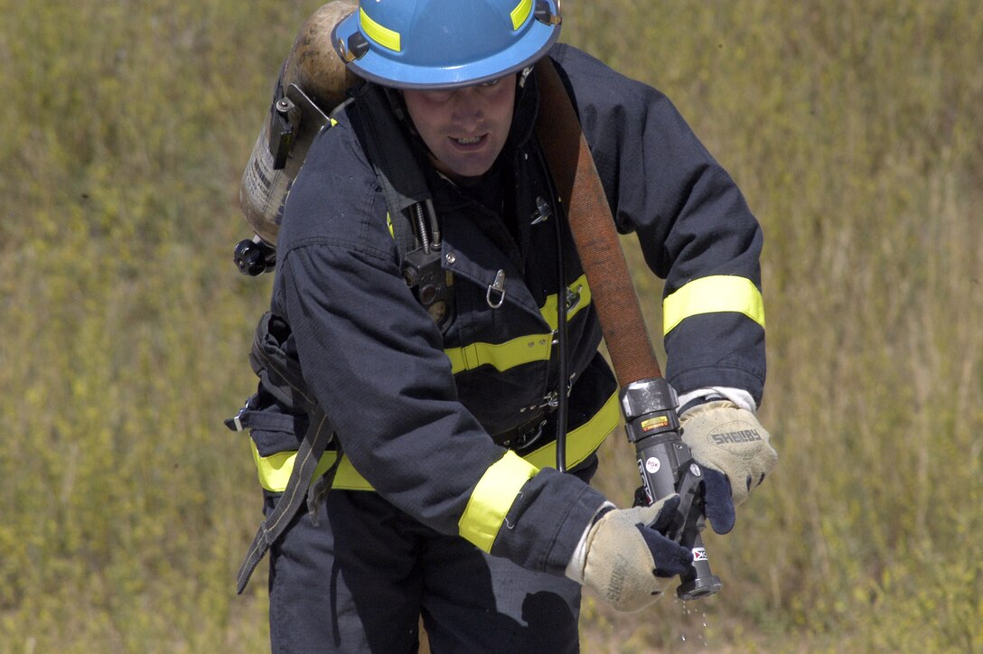 U.S. AIR FORCE ACADEMY, Colo. -- Staff Sgt. Daniel Arnes trains for a hose-drag event by pulling a fire hose 75 feet before spraying a target with it.  The hose drag is the fourth of five events which comprise the firefighter combat challenge here, and simulates real-world tasks of firefighting in a timed competition.  (U.S. Air Force photo by 2nd Lt. John Ross)
