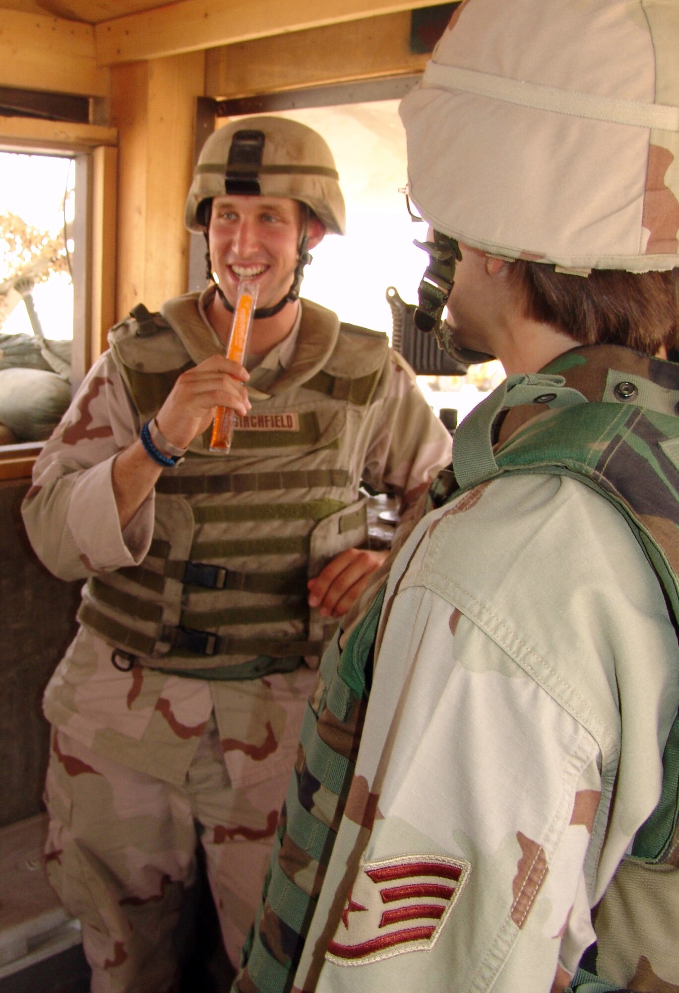 KIRKUK AIR BASE, Iraq -- Airman 1st Class Jeremy Birchfield enjoys a freezer pop given by Staff Sgt. Bobbi Russell on behalf of a noncommissioned officer organization here, which distributed more than 800 freezer pops to security forces Airmen.  Airman Birchfield is assigned to the 506th Expeditionary Security Forces Squadron, and Sergeant Russell is with the 506th Expeditionary Services Squadron. (U.S. Air Force photo by Tech. Sgt. J. Lavoie)