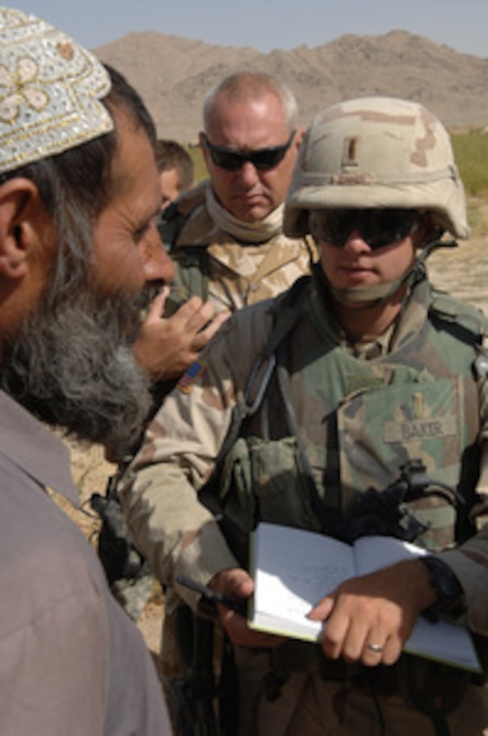 Army 1st Lt. Greg Baker (right) listens as the village elder talks to him through an interpreter in the town of Zaker-e Sharif, Afghanistan, on Aug. 18, 2005. Baker is attached to the Army's 3rd Battalion Field Artillery. 