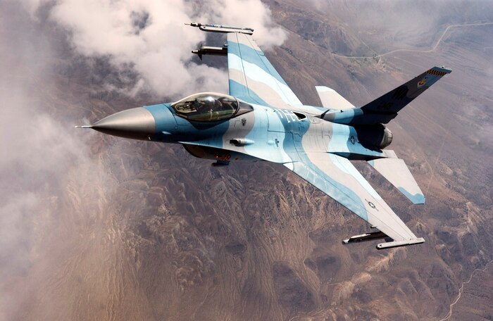 OVER NEVADA -- An F-16 Falcon from the 64th Aggressor Squadron at Nellis Air Force Base, Nev., prepares to continue its mission after refueling during a Red Flag mission recently.  The F-16s have a unique paint scheme to match their role as simulated enemy Mig aircraft during quarterly Red Flag exercises.  (U.S. Air Force photo by Master Sgt Robert W. Valenca)