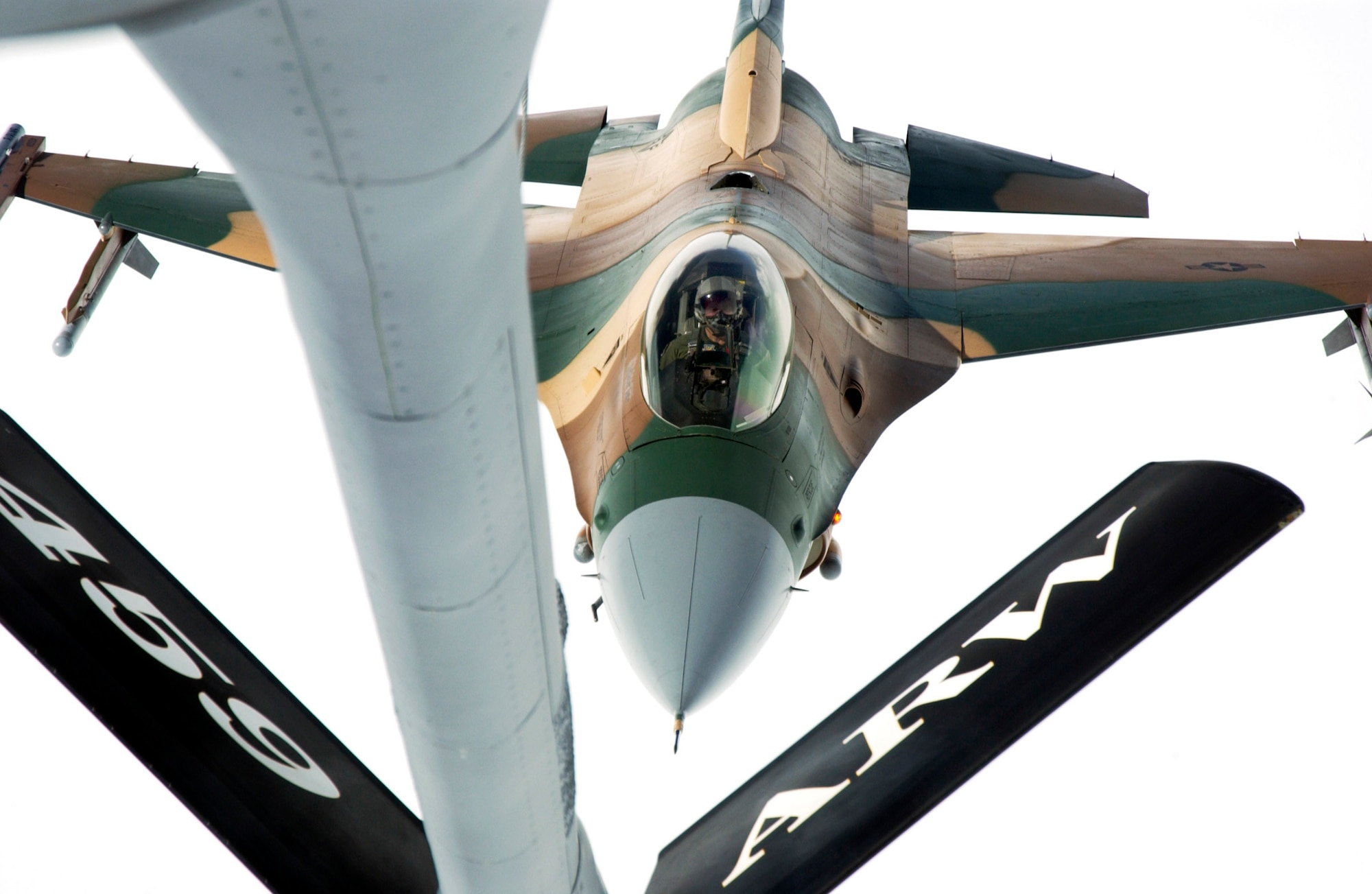 OVER NEVADA -- An F-16 Fighting Falcon from the 64th Aggressor Squadron at Nellis Air Force Base, Nev., approaches the boom on of a KC-135 Stratotanker to refuel during a Red Flag mission recently.  The F-16s have a unique paint scheme to match their role as simulated enemy Mig aircraft during quarterly Red Flag exercises.  (U.S. Air Force photo by Master Sgt Robert W. Valenca)