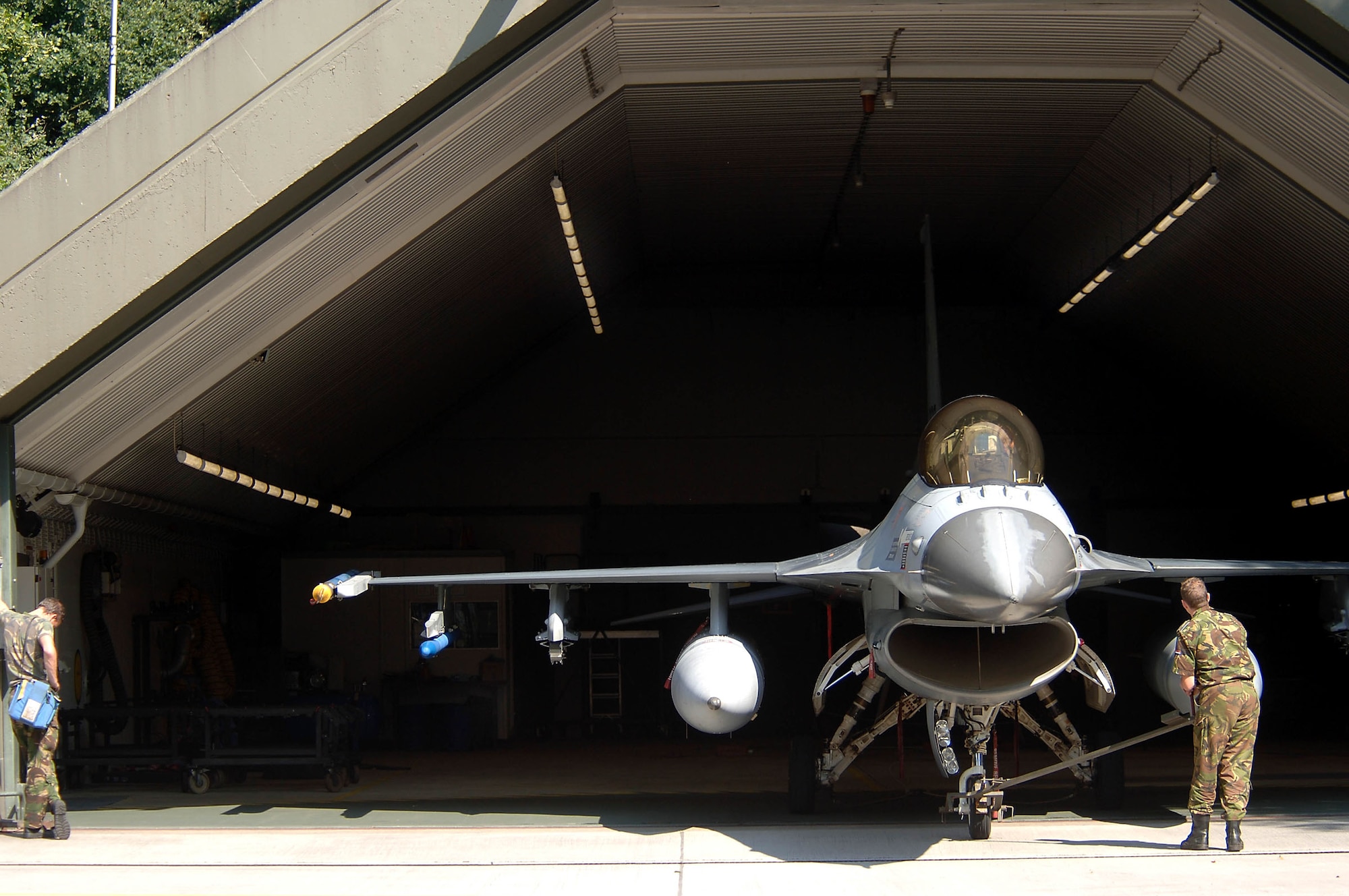 VOLKEL AIR BASE, Netherlands -- Dutch air force Sgt. Martijn De Boer (left) and Cpl. Jordy Luske tow a 306th Tactical Fighter Training Squadron F-16 Fighting Falcon into a hangar here.  The plane returned from a training flight with Lt. Col. David Stein, an Air Force exchange pilot, at the controls.  The colonel, from the Arizona Air National Guard's 162nd Fighter Wing at Tucson, Ariz., is ending a three-year tour with the Dutch air force's 1st Fighter wing.  The Dutch airmen are crew chiefs.  (U.S. Air Force photo by Senior Master Sgt. Keith Reed)