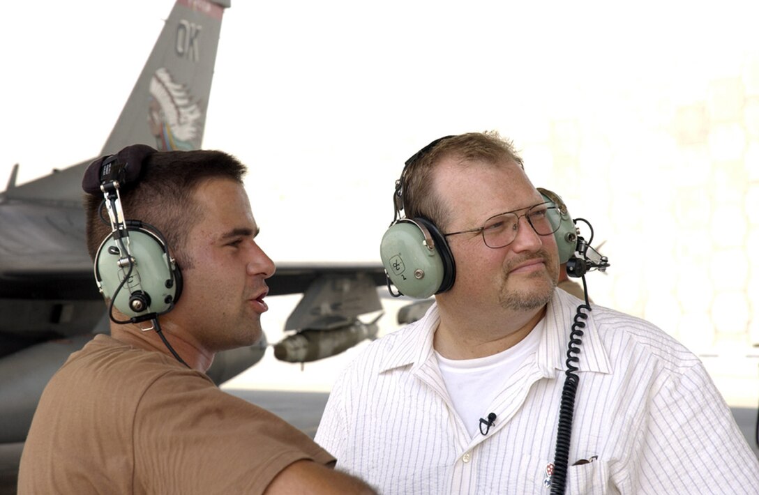 SOUTHWEST ASIA -- Staff Sgt. Andy Adducchio briefs comedian Drew Carey on his mission responsibilities Aug. 24 at this forward-deployed location.  Mr. Carey was part of a five-person comedic team traveling the area to entertain forward-deployed troops.  Sergeant Ardducchio is a crew chief with the 180th Aircraft Maintenance Unit and is deployed from the Ohio Air National Guard 's 178th Fighter Wing.  (U.S. Air Force photo by Tech. Sgt. Randy Mallard)