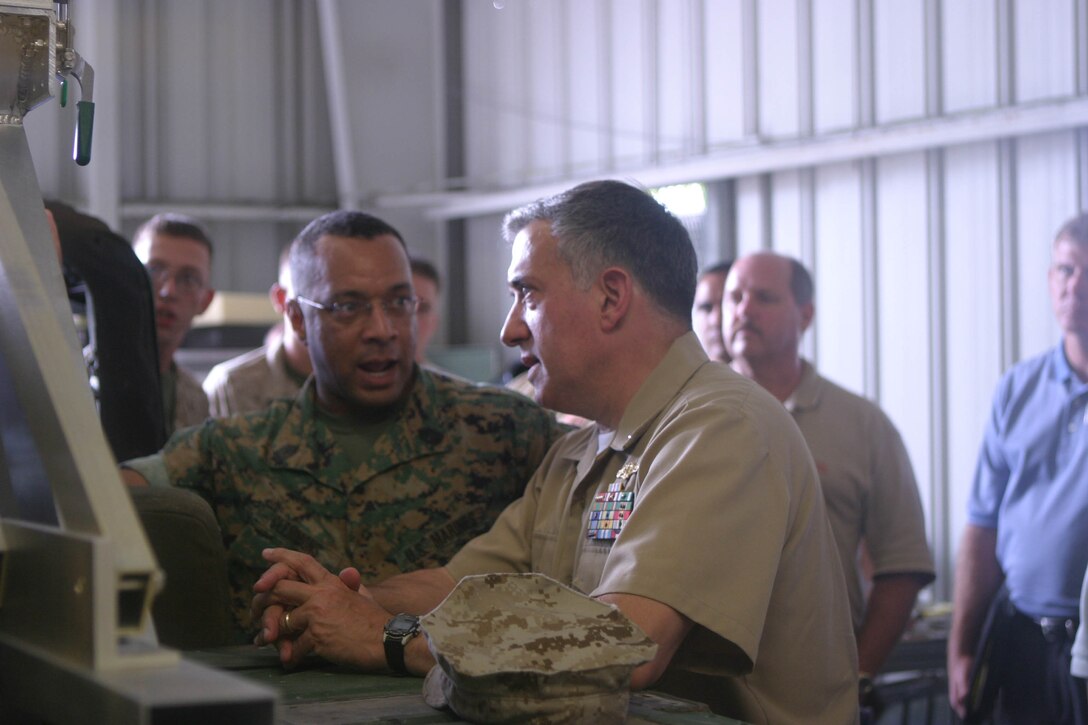 Master Gunnery Sgt. Mark E. Clemmons, Communications Chief of 3rd Marine Expeditionary Force, points out some of the controls of the M2C2 prototype to Rear Adm. Jay M. Cohen, Cheif of Naval Research, Aug. 25.