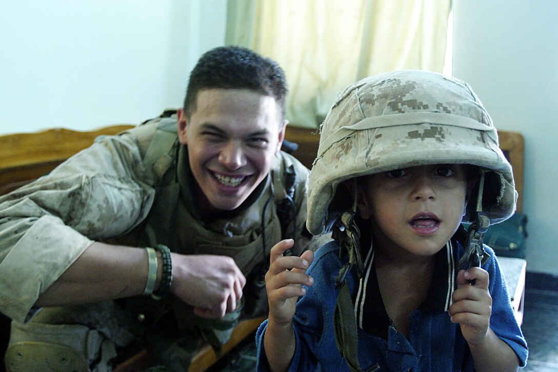 Hit, Al Anbar, Iraq (August 26, 2005)--Lance Cpl. John W. Anderson, 23 of Delmont, Penn., and assistant team leader with Company K, 3rd Battalion, 25th Marine Regiment poses for a pic with his young friend Afooie during a patrol stop. (Official USMC Photo by Cpl. Ken Melton)