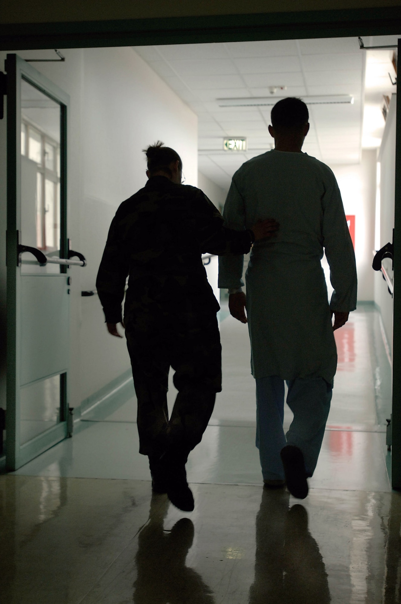 LANDSTUHL REGIONAL MEDICAL CENTER, Germany -- Airman 1st Class Cassandra Gillard (left) helps Marine Corps Cpl. Tyler Einarson walk to see a doctor who will change the dressing on his two gunshot wounds.  The 3rd Marine Division rifleman is recovering here from gunshots received to the chest and arm while on patrol in northeast Afghanistan in mid-August.  A joint team of Airmen, Soldiers, Sailors, Marines and civilians provide care for wounded troops at this medical center.  Airman Gillard is a medical technician with the 435th Medical Squadron.  (U.S. Air Force photo by Senior Master Sgt. Keith Reed)