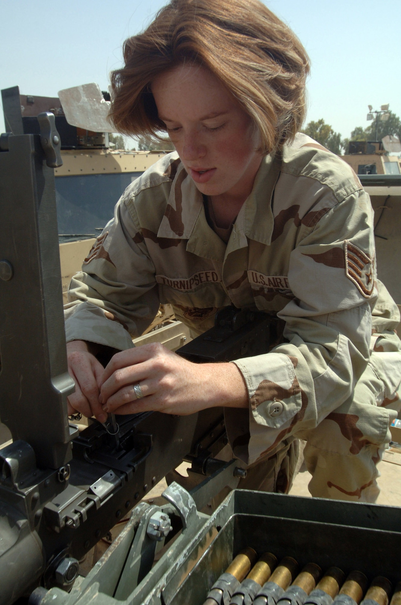 BALAD AIR BASE, Iraq -- Staff Sgt. Rebecca Turnipseed inspects a .50-caliber machine gun before a convoy escort mission.  The Air Force escort units have yet to lose a customer to enemy attack.  Sergeant Turnipseed is assigned to the 332nd Air Expeditionary Wing's Detachment 1.  (U.S. Air Force photo by Staff Sgt. Chad Chisholm)