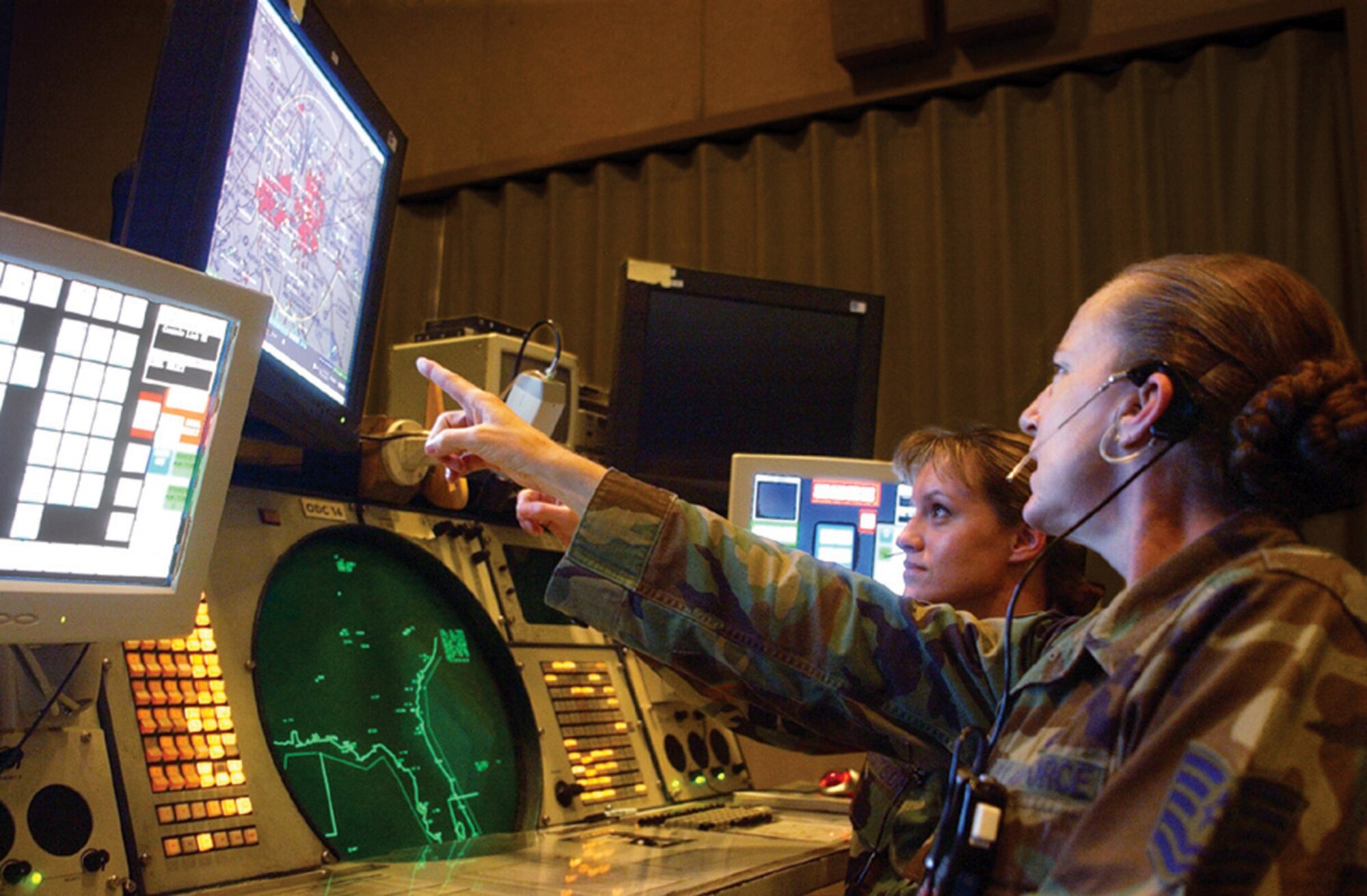TYNDALL AIR FORCE BASE, Fla. -- Tech. Sgt. Kathleen O'Brien (right) points out tracks of interest to Tech. Sgt. Christie Watson in the 1st Air Force and Continental U.S. North American Aerospace Defense Command Region combined air operations center here.  The center will be one of three primary elements in the new Air Force North warfighting headquarters.  (U.S. Air Force photo by 2nd Lt. Albert Bosco)