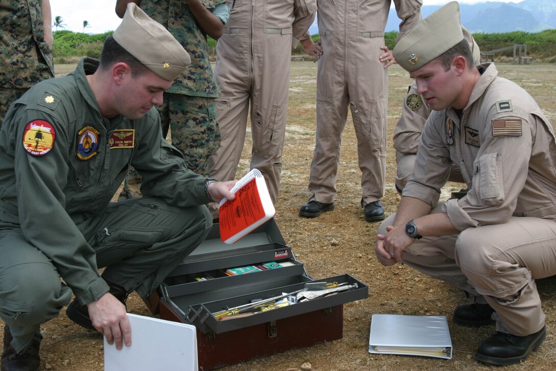 Lt. Cmdr. Colin Smith (left), and Navy Lt. Ed "Doc" Sellon, from Helicopter Anti-Submarine Squadron 37, Easyriders, review the contents of the toolbox they brought a mishap drill aboard Marine Corps Base Hawaii, Kaneohe Bay.  This and other gear would be brought on sight in the event that a helicopter crash occured on K-Bay or the surrounding area. Members of more than 10 units and civilian agancies met Aug. 26 to discuss procedures, should there be a mishap on the base.