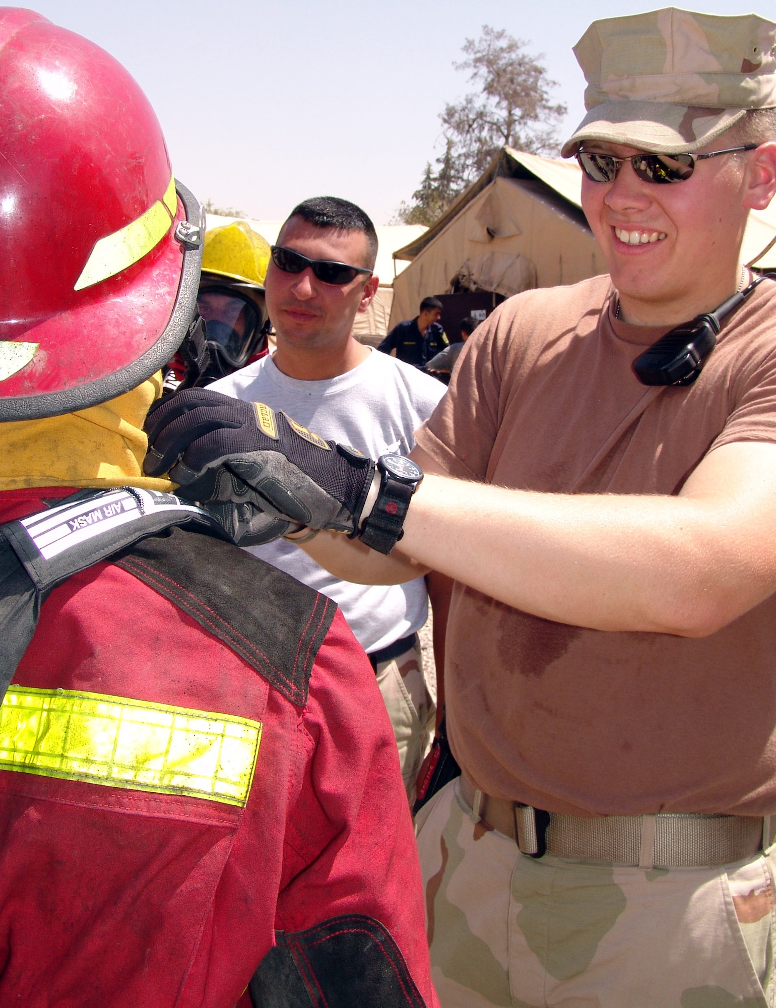 KIRKUK AIR BASE, Iraq -- Senior Airman Kyle Milan adjusts an Iraqi's gear before he enters a training fire.  Many of the Iraqis being trained are first responders for oil pipeline fires.  Airman Milan is assigned to the 506th Expeditionary Civil Engineer Squadron.  (U.S. Air Force photo by Tech. Sgt. J. LaVoie)