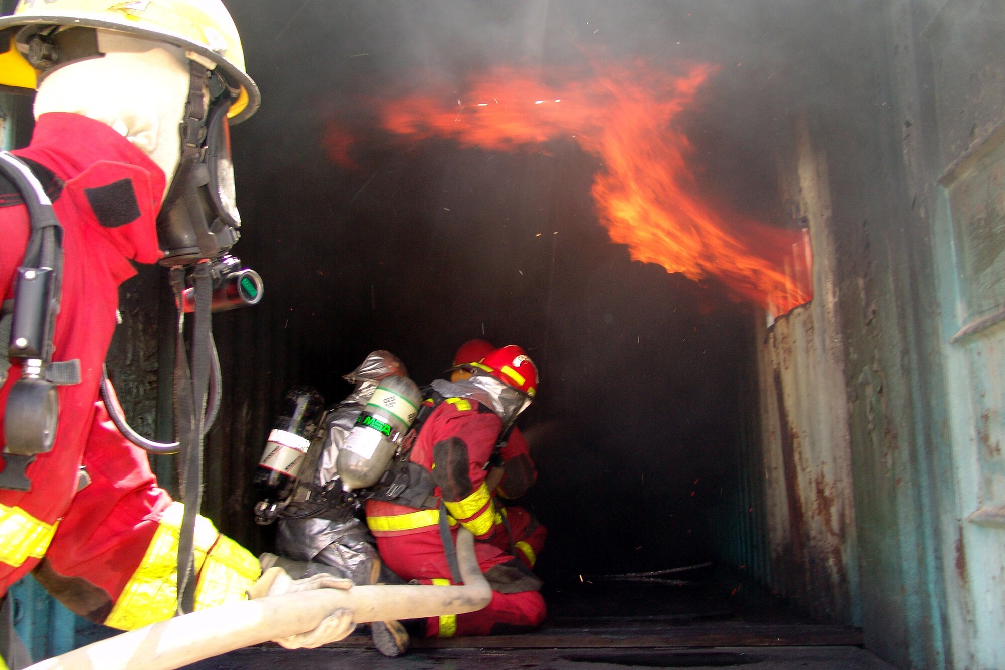 KIRKUK AIR BASE, Iraq -- A firefighter with the 506th Expeditionary Civil Engineer Squadron leads three Iraqi firefighters into a Conex here designed for training.  The Iraqis attended three days of training that culminates in putting out an actual fire.  (U.S. Air Force photo)