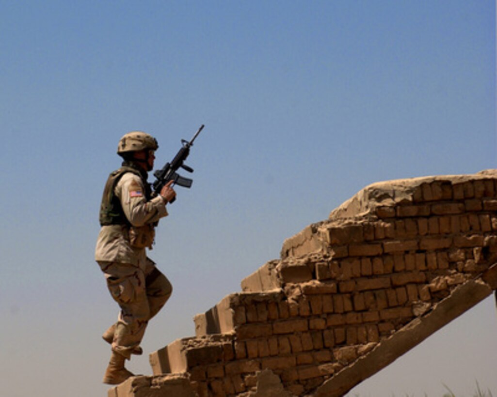 Army Sgt. Jared Seiler searches for the triggermen who remotely detonated an improvised explosive device and damaged a Humvee in Tarmiya, Iraq, on Aug. 22, 2005. Seiler is attached to the 1st Battalion, 13th Armor Regiment, 3rd Brigade, 1st Armored Division. 