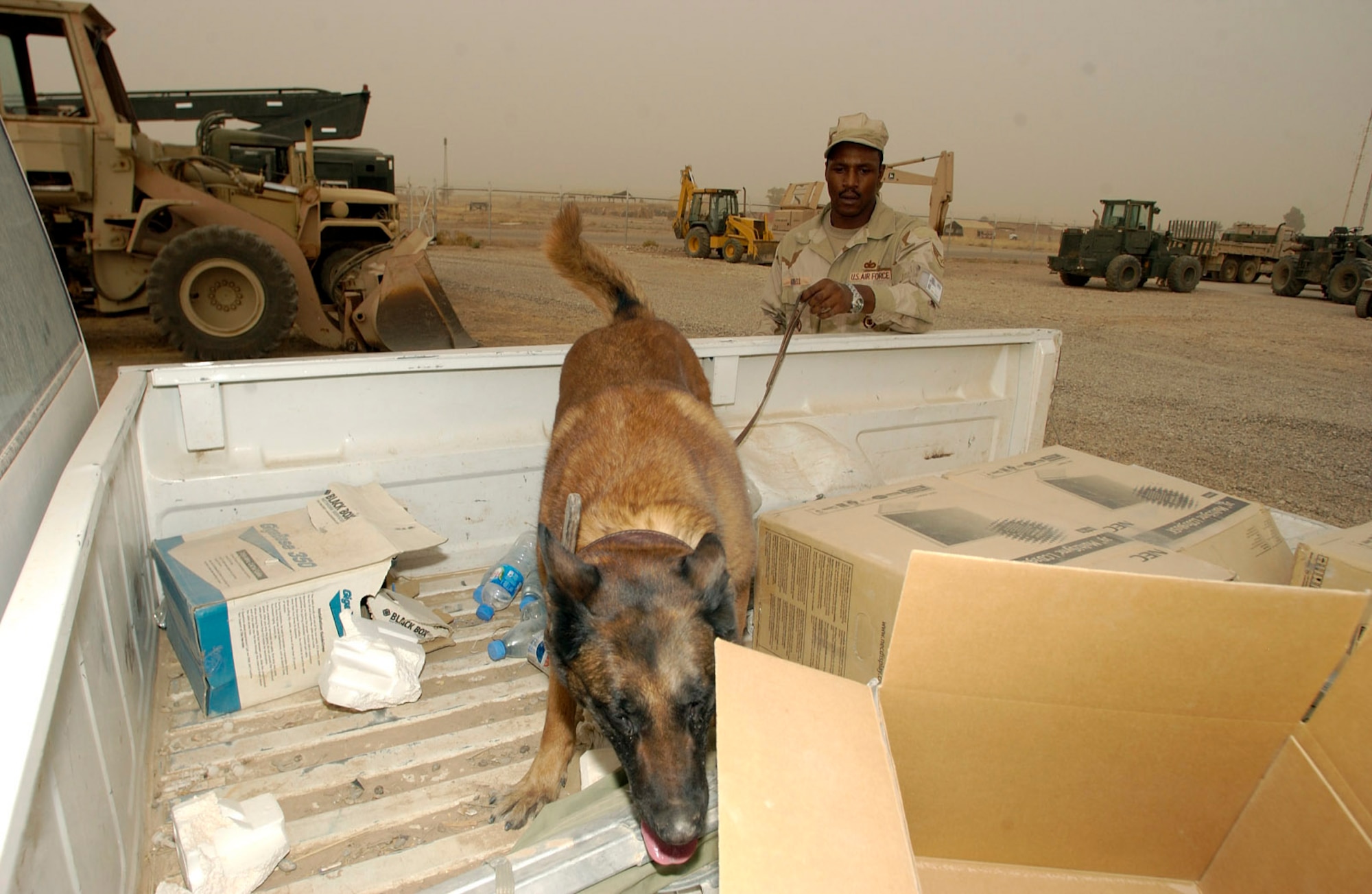 KIRKUK AIR BASE, Iraq -- Staff Sgt. Willie Harrell and his military working dog, Tasja, search a truck during training here.  The K-9 teams perform constant training to ensure they are working as a team.  Sergeant Harrell is assigned to the 506th Expeditionary Security Forces Squadron.  (U.S. Air Force photo by Tech. Sgt. Christopher Gish)