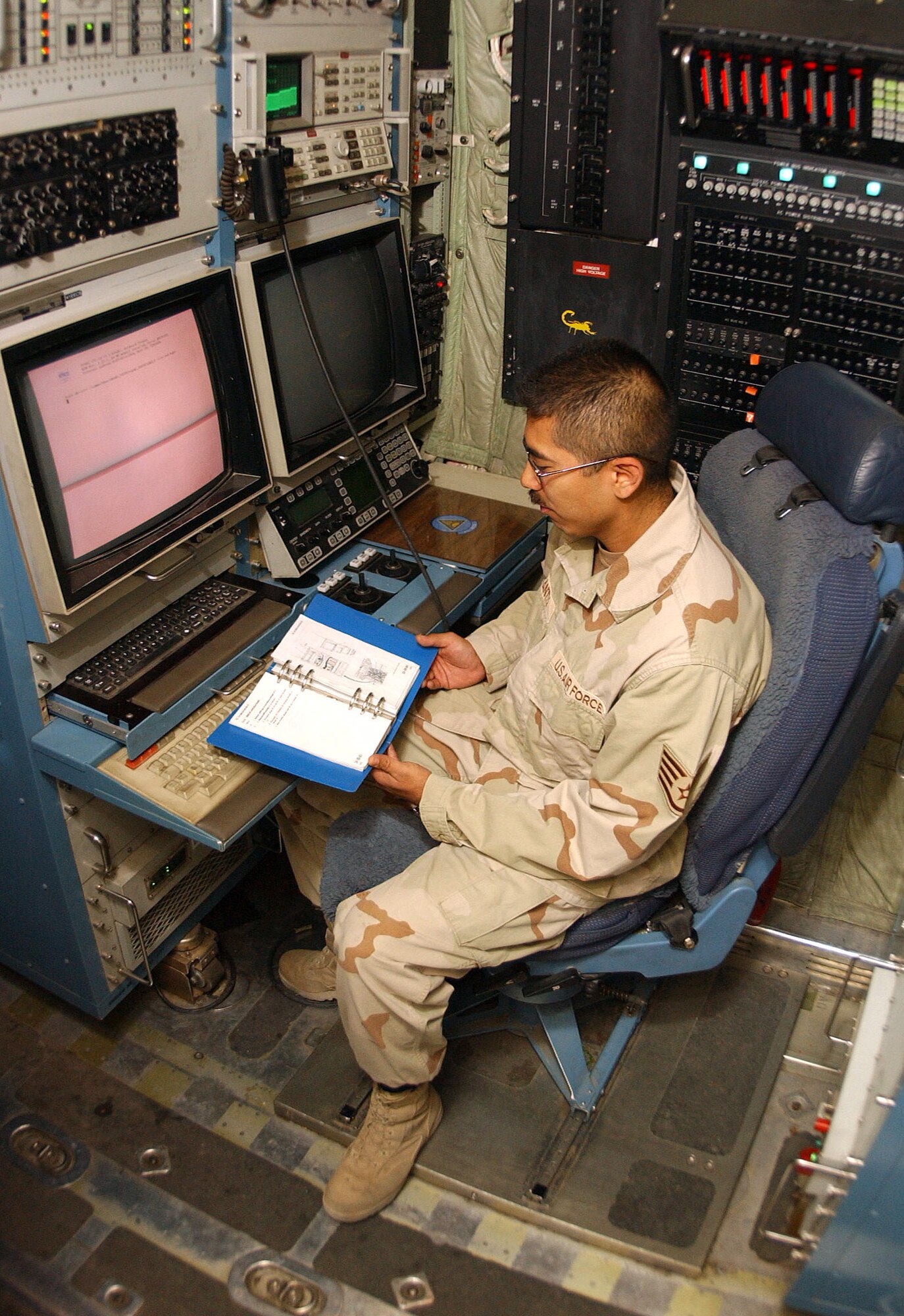 BAGRAM AIR BASE, Afghanistan -- Staff Sgt. Robert Cantu studies a system operating job guide before performing tactical command, control and communications countermeasures in an EC-130H Compass Call.  Sergeant Cantu is the production superintendent for the 41st Expeditionary Electronic Combat Squadron and is deployed from Davis-Monthan Air Force Base, Ariz. (U.S. Air Force photo by Airman 1st Class Desiree L. Hayden)