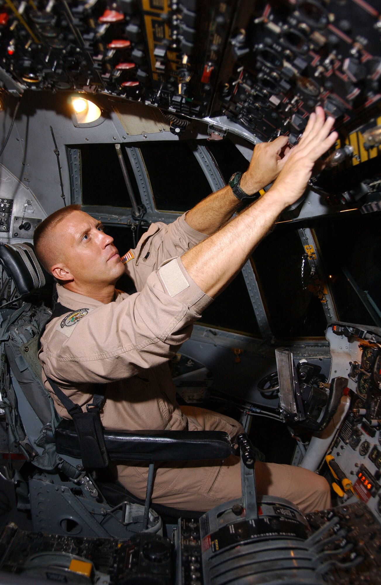 BAGRAM AIR BASE, Afghanistan -- Master Sgt. Scott Drayna performs a routine check in the flight deck of an EC-130H Compass Call before performing tactical command, control and communications countermeasures. Sergeant Drayna is a flight engineer with the 41st Expeditionary Electronic Combat Squadron and is deployed from Davis-Monthan Air Force Base, Ariz. (U.S. Air Force photo by Airman 1st Class Desiree L. Hayden)