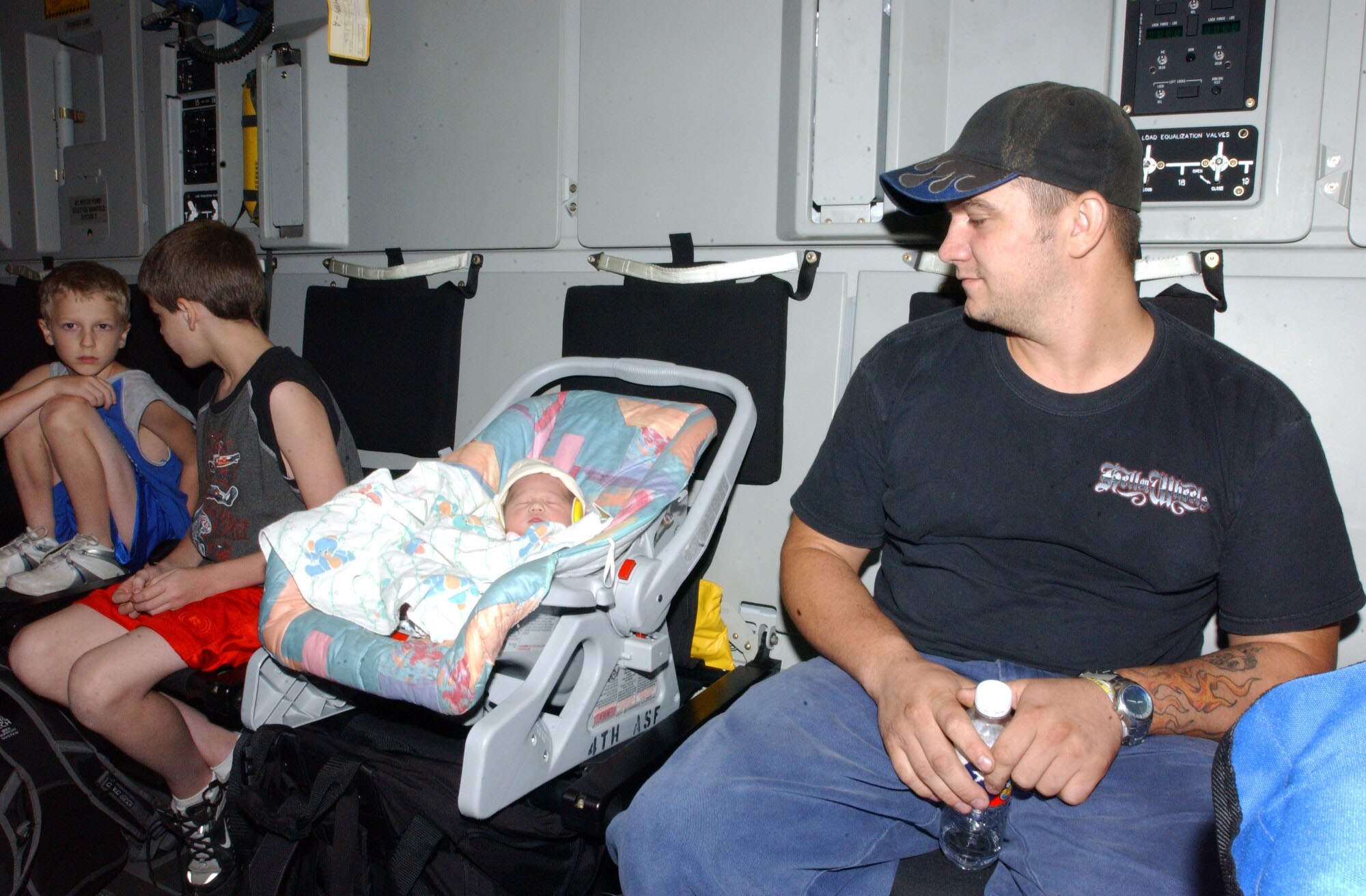 LACKLAND AIR FORCE BASE, Texas -- Airman Aaron Post and his family wait to leave a C-17 Globemaster III here after being evacuated from Keesler Air Force Base, Miss., in the wake of Hurricane Katrina on Aug. 30. Airman Post's wife gave birth to their daughter during the hurricane without any power in the hospital at Keesler. He is assigned to 81st Transportation Squadron. (U.S. Air Force photo by Senior Airman Heather M. Norris) 