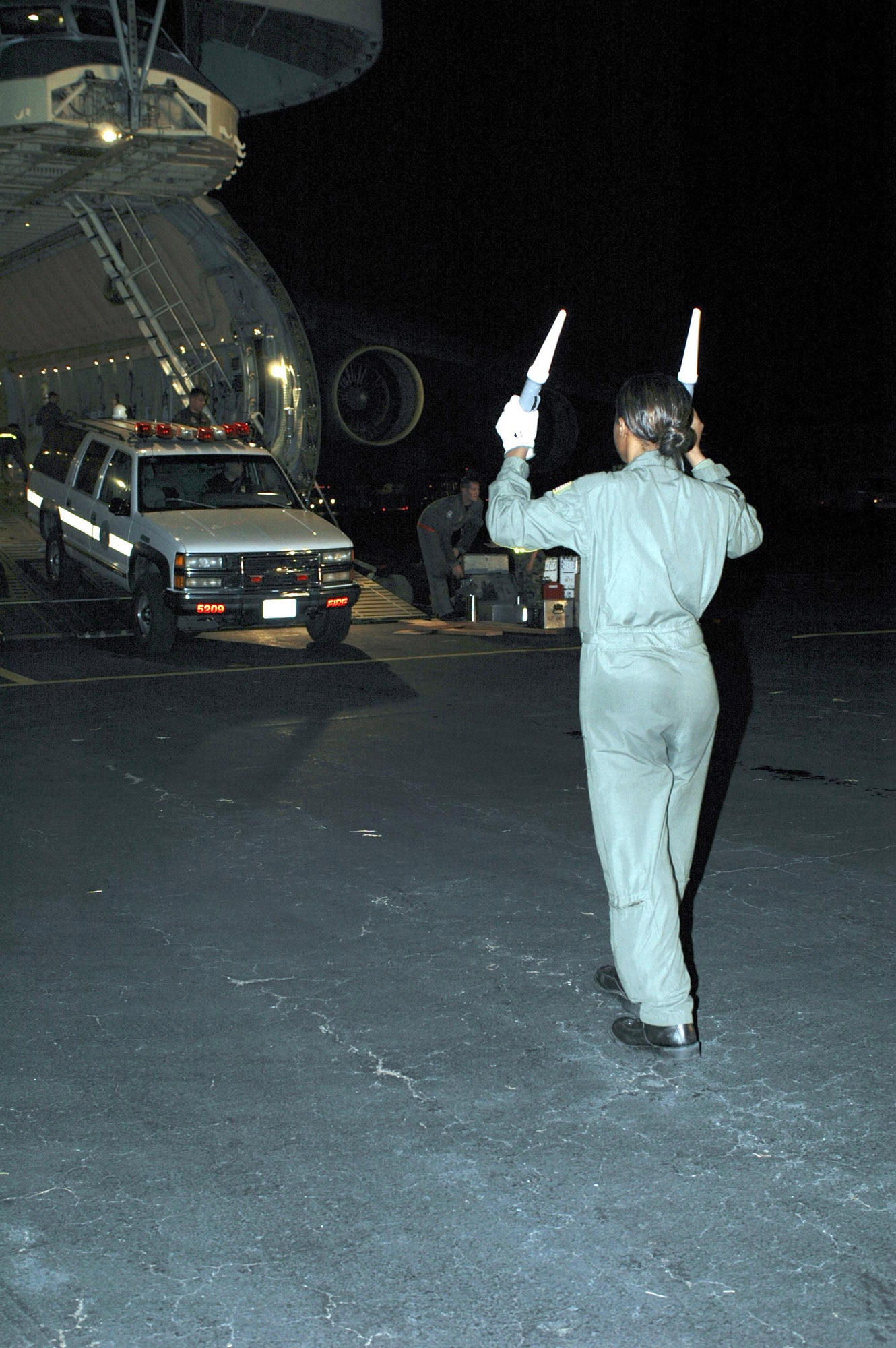 LAFAYETTE, La. -- Airman 1st Class Alicia Hudson marshals an emergency vehicle as it is unloaded here from a C-5 Galaxy on Aug. 30.  The vehicle will be used in Hurricane Katrina relief operations in Mississippi and Louisiana.  Airman Hudson is a loadmaster with the 21st Airlift Squadron at Travis Air Force Base, Calif.  (U.S. Air Force photo by Staff Sgt. Candy Knight)