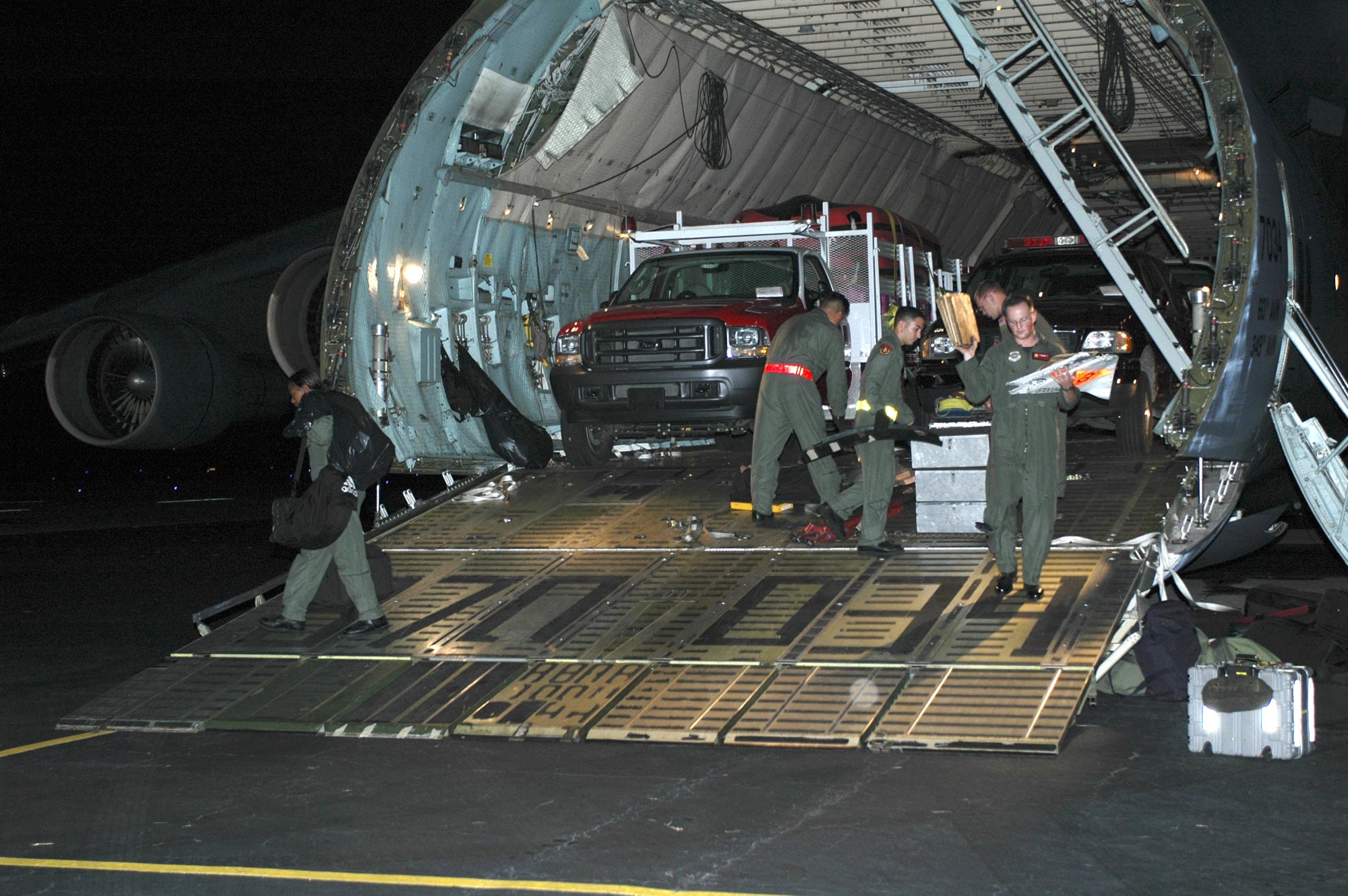 LAFAYETTE, La. -- Airmen with the 21st Airlift Squadron from Travis Air Force Base, Calif., prepare to unload emergency rescue equipment here from a C-5 Galaxy on Aug. 30.  The equipment will be used for Hurricane Katrina relief operations in Mississippi and Louisiana.  (U.S. Air Force photo by Staff Sgt. Candy Knight)