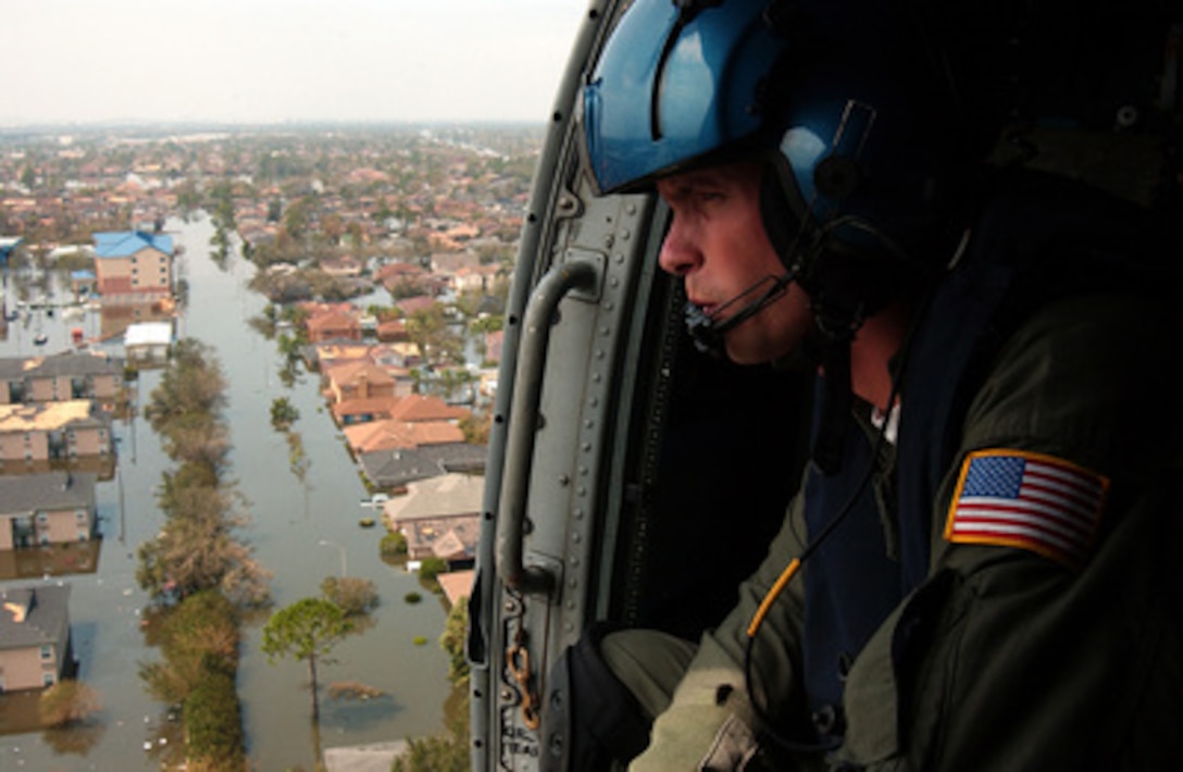Coast Guard Petty Officer 2nd Class Shawn Beaty looks for survivors in the wake of Hurricane Katrina in New Orleans, La., on Aug. 30, 2005. Beaty, 29, of Long Island, N.Y., is a member of a Coast Guard HH-60 Jayhawk helicopter rescue crew sent from Clearwater, Fla., to assist in search and rescue efforts. 