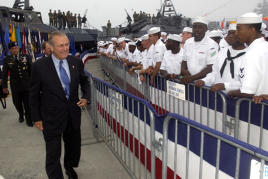 Secretary of Defense Donald H. Rumsfeld greets U.S. Navy sailors as he makes his way to his seat at the ceremony commemorating the 60th anniversary of V-J Day at Naval Air Station North Island in San Diego, Calif., on Aug. 30, 2005. Rumsfeld is joining President George W. Bush at the ceremony. 