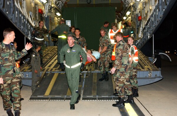 Image of Airmen transporting a patient off a plane.