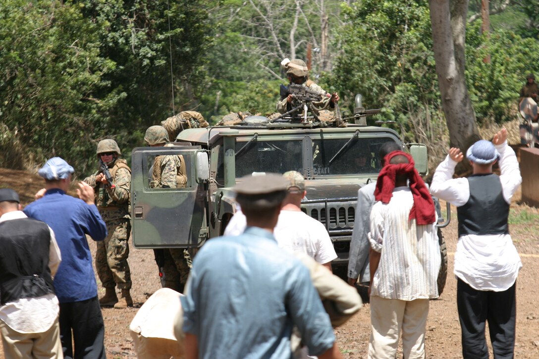 Marines with Combined Anti-Armor Team Platoon, Weapons Company, 1/3, attempt to keep the villagers of Baraki away from their Humvee, Aug, 31, during a battalion field exercise at the Military Operations in Urban Terrain facility, at Schofield Barracks. In a deadly misunderstanding, the Marines opened fire on the non-hostile villagers, role-players from Combat Service Support Group 3, killing their town elders. A mistake that later caused a village riot. The Marines were conducting a cordon and search of the village with the intent on locating enemy weapons and insurgents when the mission went awry and innocent villagers were shot.