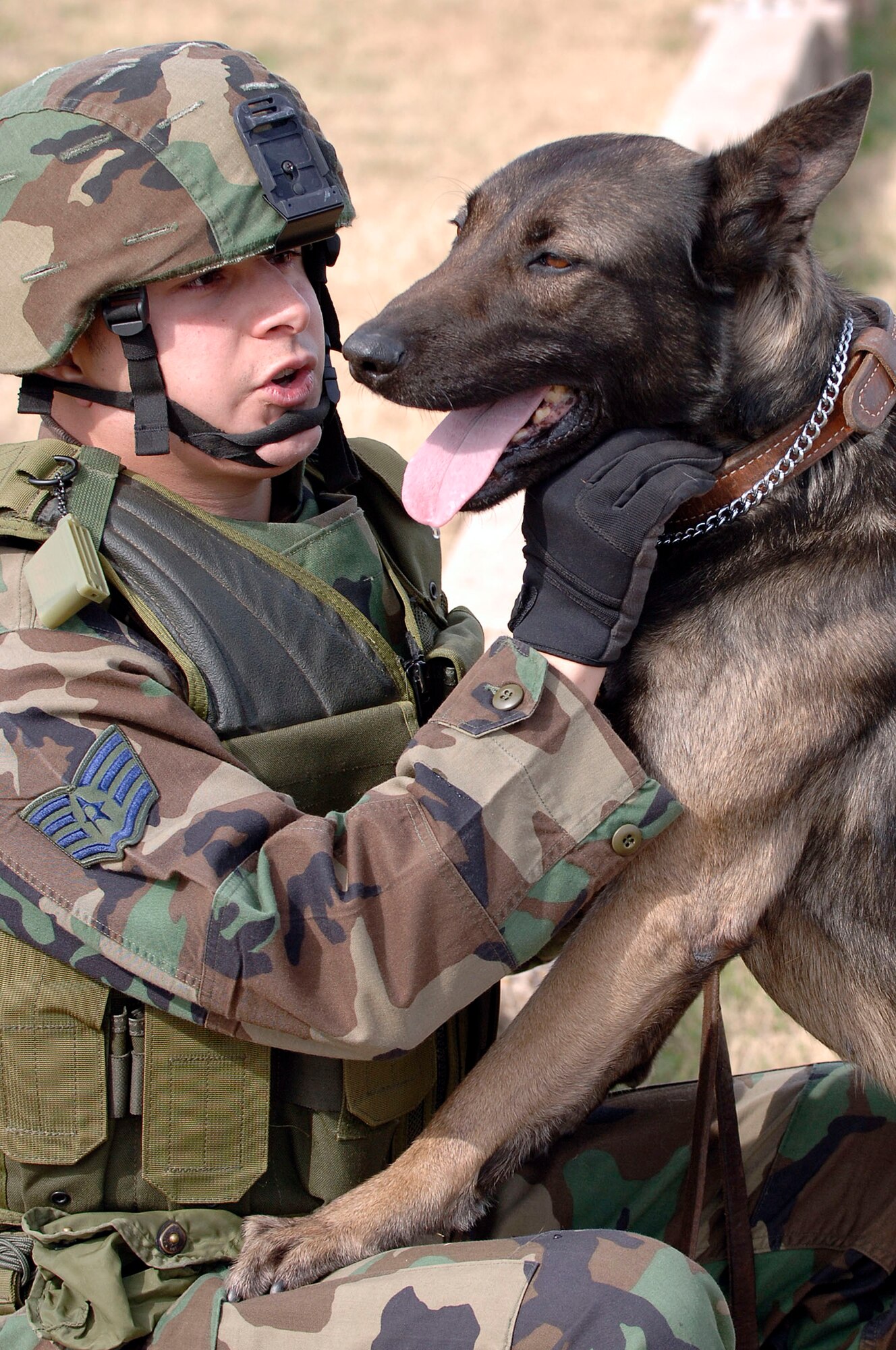 BARKSDALE AIR FORCE BASE, La. (AFPN) -- Staff Sgt. Jessie Mendez and his military working dog, Robby, wait to take part in the base's expeditionary combat skills training course. The weekly course, which ends this month, prepares Airmen for deployment. Military working dogs are now part of the course to help provide a more realistic training experience. Sergeant Mendez and Robby are both with the 2nd Security Forces Squadron. (U.S. Air Force photo by Senior Airman Stephen J. Otero)