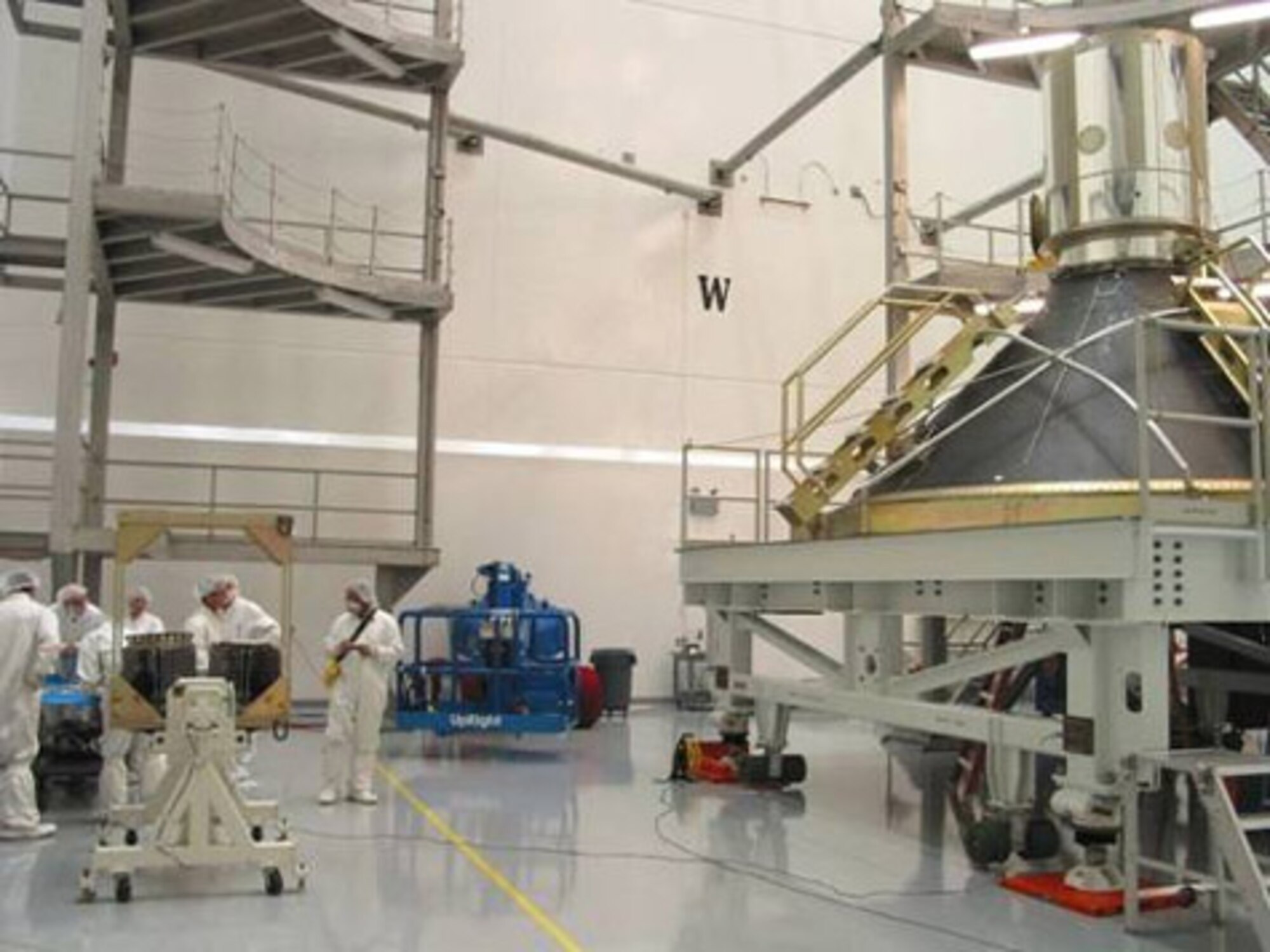KIRTLAND AIR FORCE BASE, N.M. (AFMCNS) -- NanoSat-2 (two satellites sitting on the triangular white stand, lower left-hand corner) undergo integration and testing at Air Force Research Laboratory, Space Vehicles Directorate, Kirtland Air Force Base, N.M. The Boeing Delta-IV heavy is on the right with DemoSat (the other payload) on top of it. (Air Force photo courtesy of Scott Franke)