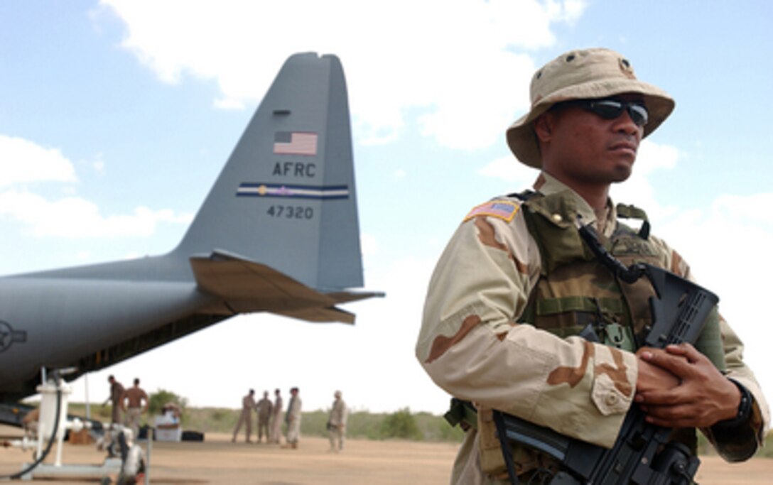 Army Spc. Tulen Nena stands guard on the flight line while equipment is being off-loaded from a U.S. Air Force C-130 Hercules aircraft in Gode, Ethiopia, on Nov. 23, 2005. Members of the U.S. Army well drilling team from the 747th Engineer Detachment, Montana, are deployed to Gode with the task of digging four wells so people in the surrounding areas will have consumable water. Nena is deployed to Combined Joint Task Force-Horn of Africa from the 1-294th Infantry, Guam. 