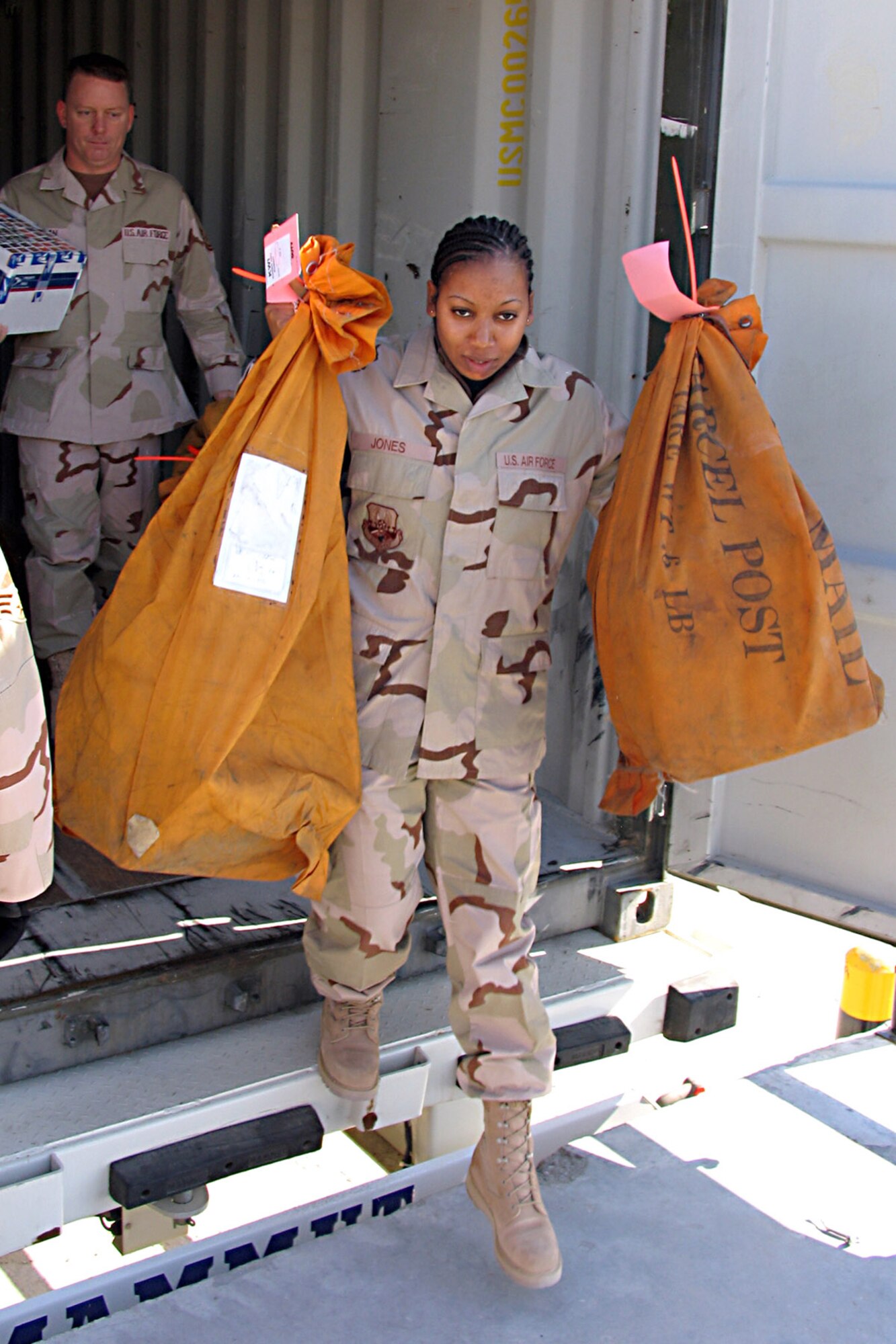 SOUTHWEST ASIA (AFPN) -- Senior Airman Isis Jones helps unload the daily mail truck at an air base in Southwest Asia. Airman Jones is a postal volunteer. (U.S. Air Force photo by Tech. Sgt. Mark Getsy)