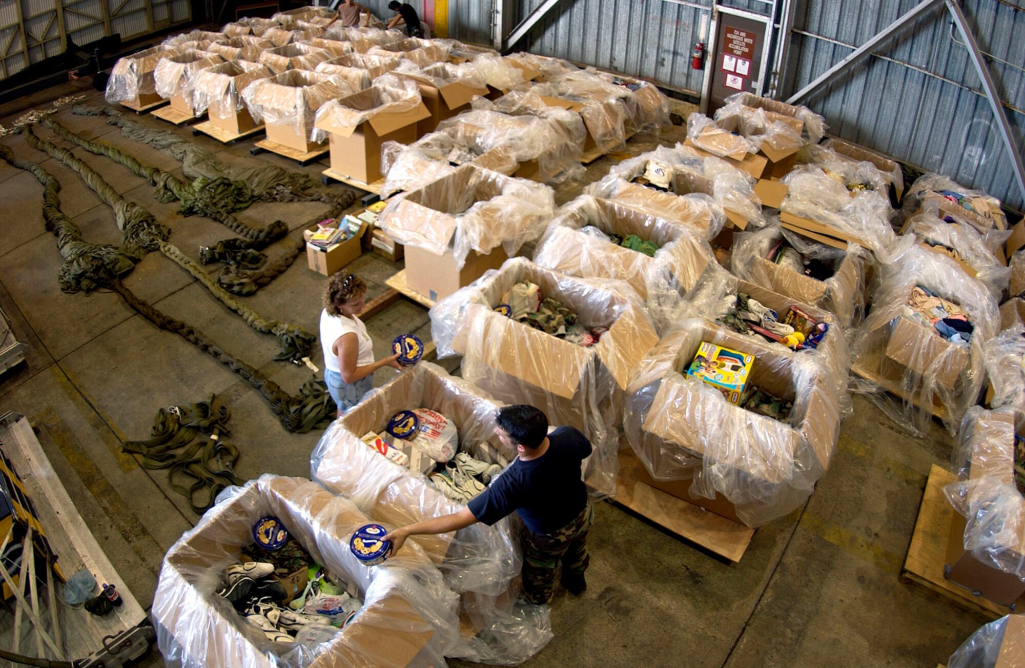 ANDERSEN AIR FORCE BASE, Guam (AFPN) -- Volunteers sort donated Operation Christmas Drop food items into individual boxes at a collection center in Hangar 5 here today. The donations will be used in this year's Operation Christmas Drop, a 53-year-old tradition. C-130 Hercules aircraft from Yokota Air Base, Japan, flew here today, load up the donated gifts and "deliver" them via parachute to remote Micronesian islands. (U.S. Air Force photo by Staff Sgt. Bennie J. Davis III)