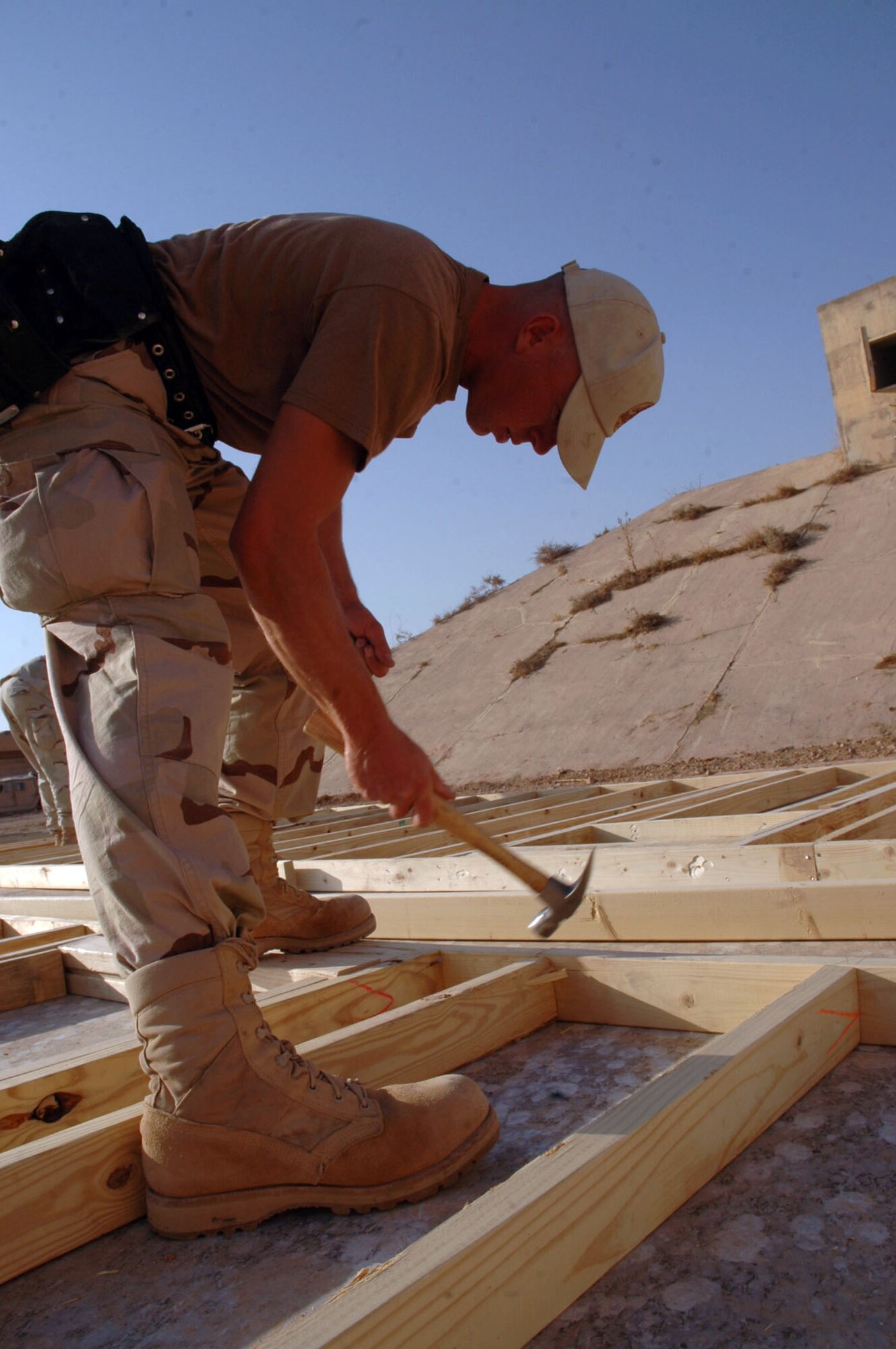 FORWARD OPERATION BASE QAYYARAH WEST, Iraq (AFPN) -- Senior Airman Jesse Gent hammers a piece of wood into place on a new building here. Airman Gent is a structural journeyman with the 557th Expeditionary Red Horse Squadron. (U.S. Army photo by Spc. Jeremy D. Crisp)