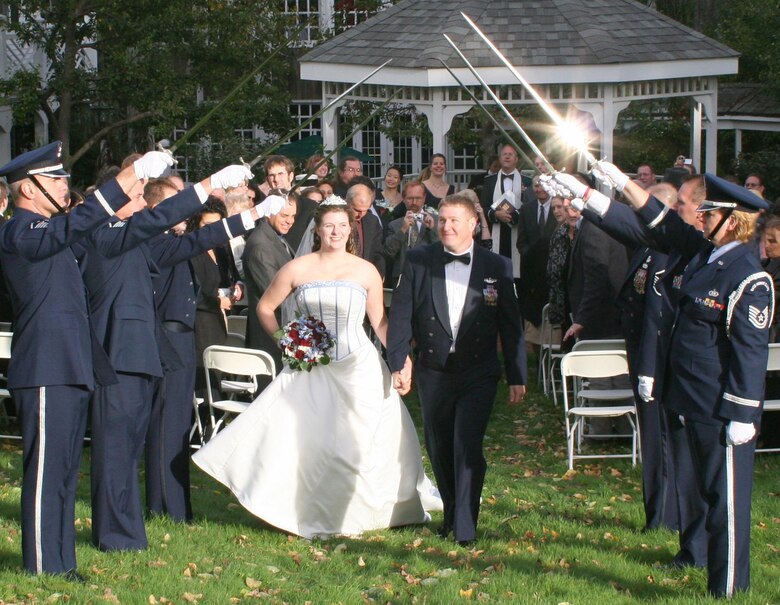 MILITARY WEDDING -- Tech. Sgt. Kevin P. Godbout and his new wife, Chrissa, walk beneath the arch of sabres, the traditional millitary passageway for newlyweds.

