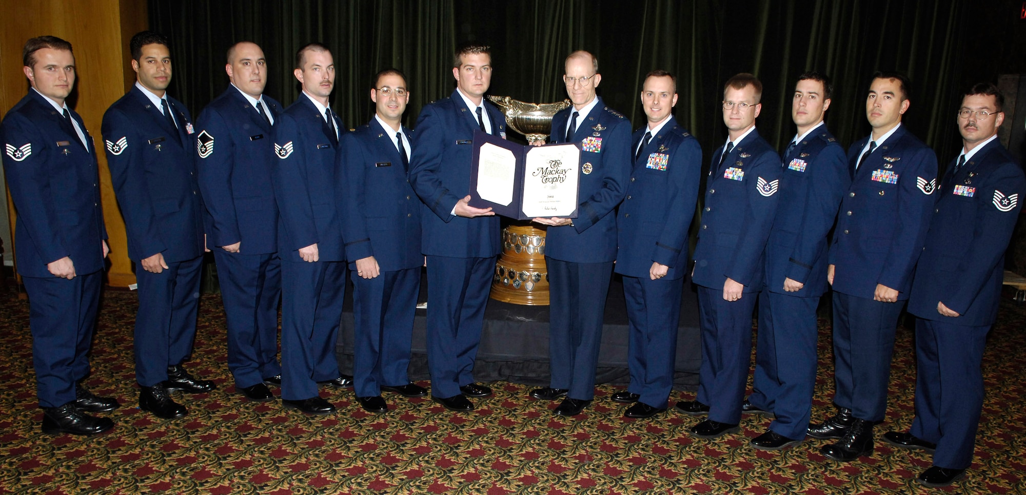 ARLINGTON, Va. (AFPN) - Gen. John D. W. Corley, the Air Force vice chief of staff, (center right) presents the Mackay Trophy to the Airmen who rescued five Soldiers after their helicopter crashed in Iraq. They are (left to right) Staff Sgt. Vincent J. Eckert, Staff Sgt. John Griffin, Master Sgt. Paul Silver, Staff Sgt. Patrick Ledbetter, Maj. Joseph Galletti, Capt. Robert Wrinkle, Capt. Greg Rockwood, Tech. Sgt. Michael Preston, Capt. Bryan Creel, Staff Sgt. Michael Rubio and Tech. Sgt. Thomas Ringheimer. Not present at the ceremony were Tech. Sgt. Matt Leigh and Senior Airman Edward Ha. (U.S. Air Force photo by Donna Parry)