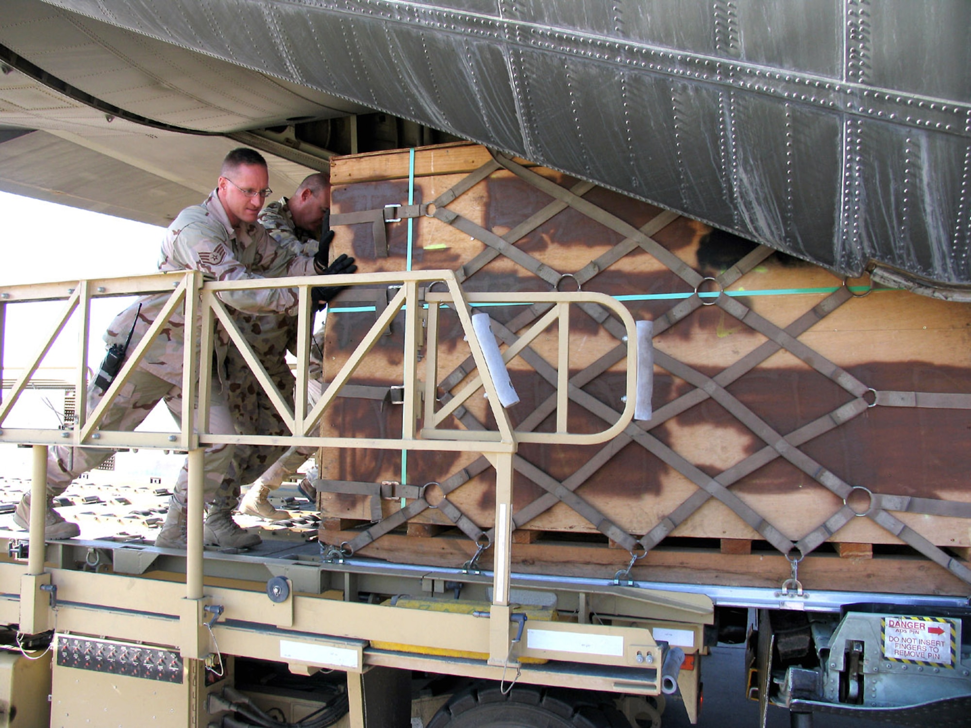 SOUTHWEST ASIA (AFPN) -- Staff Sgt. Stefan Halushka helps an Australian C-130 Hercules technician load a cargo pallet onto an Australian cargo aircraft. Sergeant Halushka is with the 386th Expeditionary Logistics Readiness Squadron and deployed from the 919th Logistics Readiness Squadron at Eglin Air Force Base, Fla. (U.S. Air Force photo by Staff Sgt. Scott Campbell)