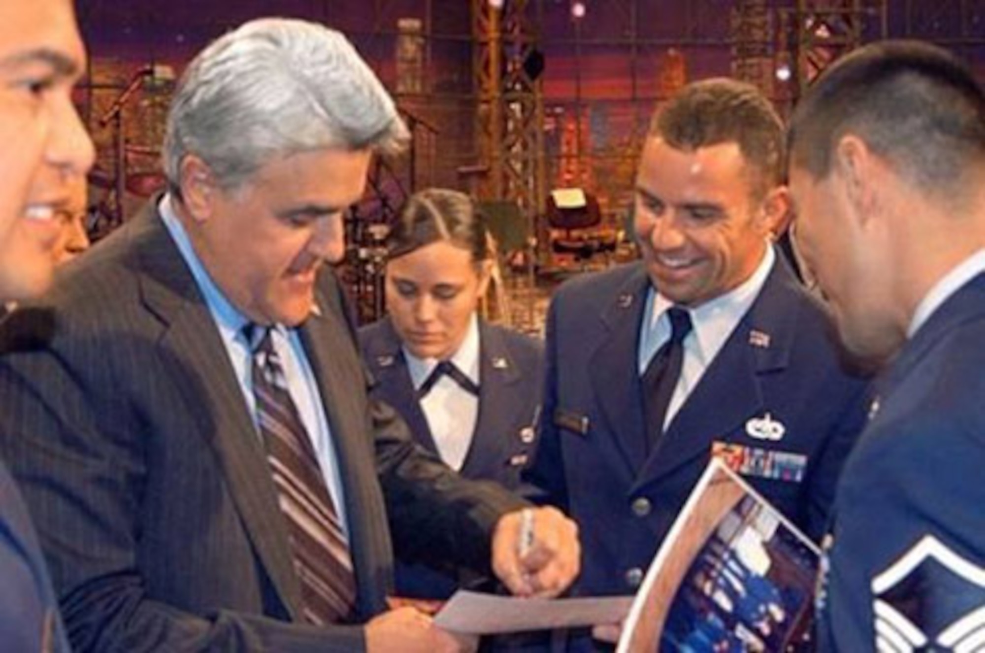 BURBANK, Calif. (AFMCNS) - Jay Leno, host of "The Tonight Show," autographs a photo for Master Sgt. Michael Hordichok, 31st Test and Evaluation Squadron program manager, at NBC Studios in Burbank, Calif., on Nov. 22. Mr. Leno invited more than 350 servicemembers, including 55 Airmen from Edwards, to be the audience for the taping of his Thanksgiving Day episode. (Air Force photo)
